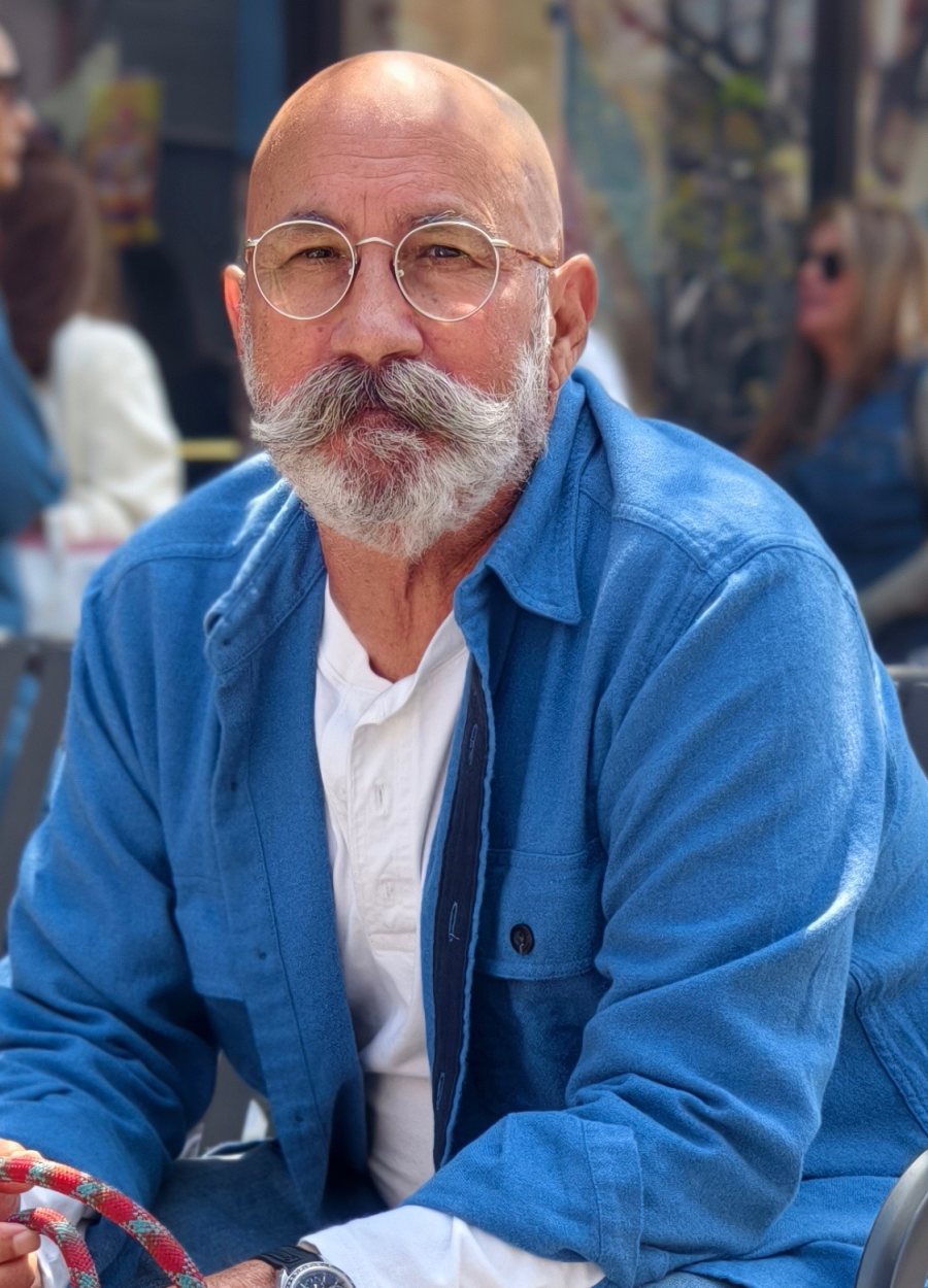 Jeff, The Pocket Watch Guy, seated outdoors in a blue work shirt