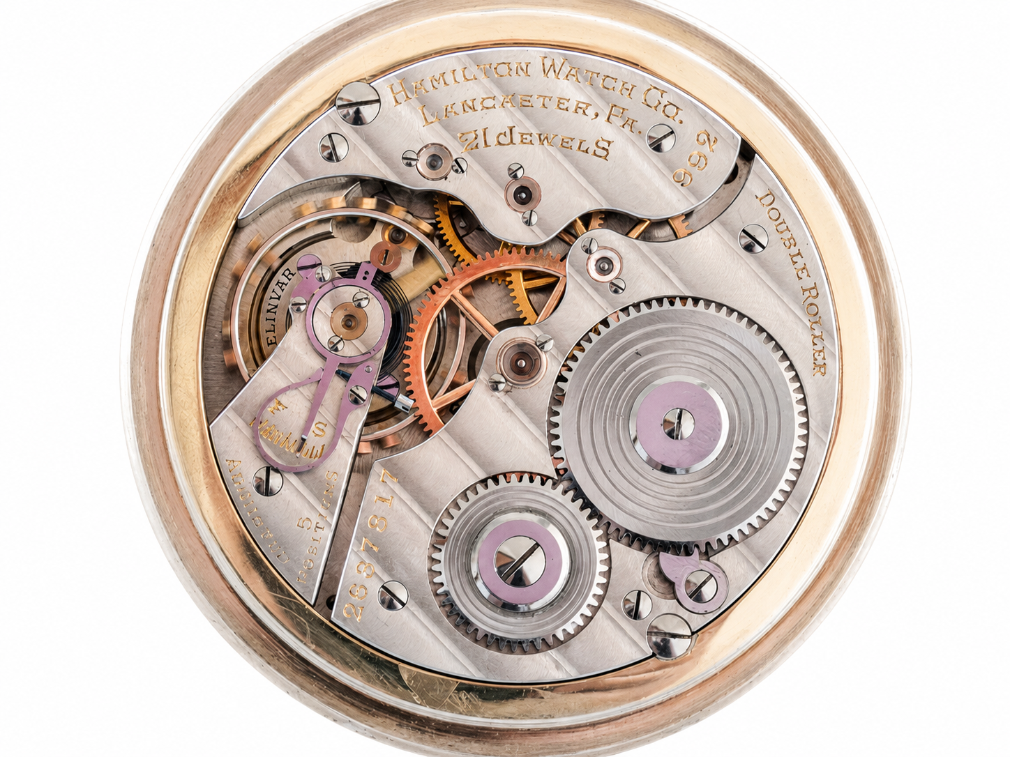 Open pocket watch movement with visible gears, springs, and jeweled components in a gold case.