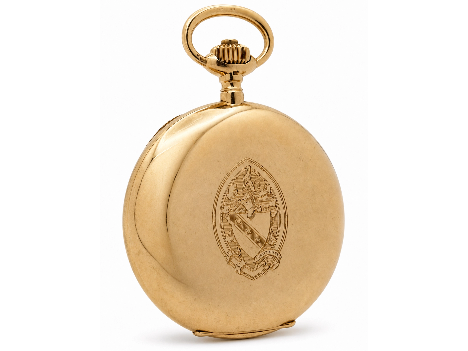 Closed gold pocket watch case with engraved oval heraldic crest and loop bail.