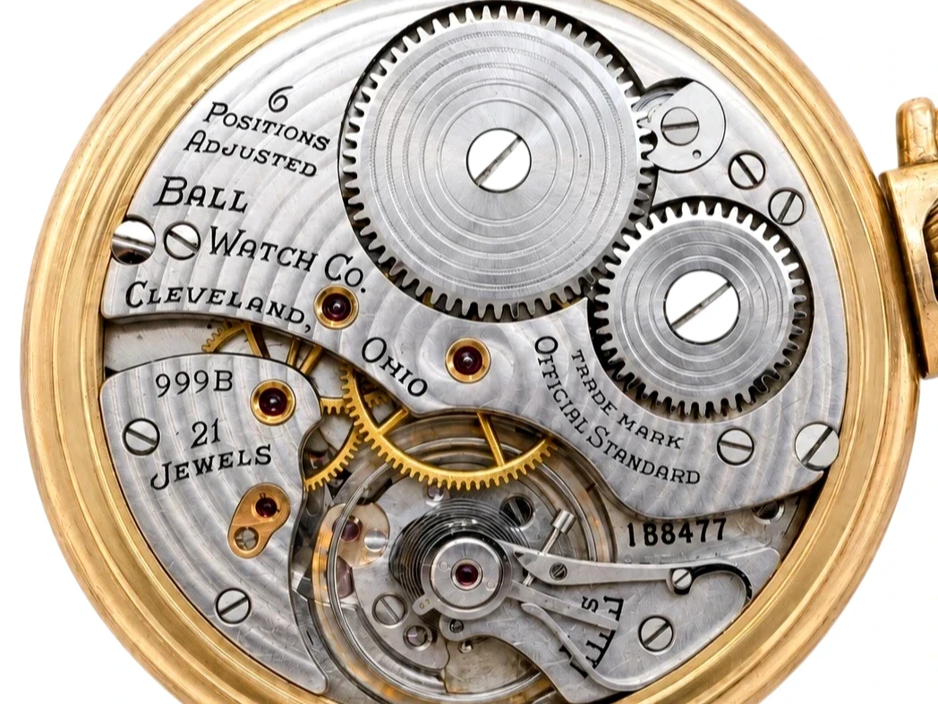 Open pocket watch movement with exposed gears, jewels, and engraved Ball Watch Co. Cleveland, Ohio plate.