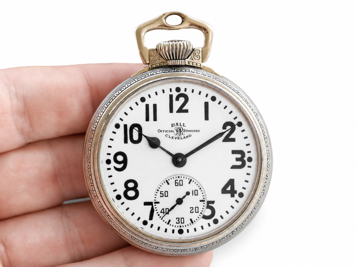 Open-face pocket watch with Arabic numerals, subsidiary seconds dial, and decorative case bezel.