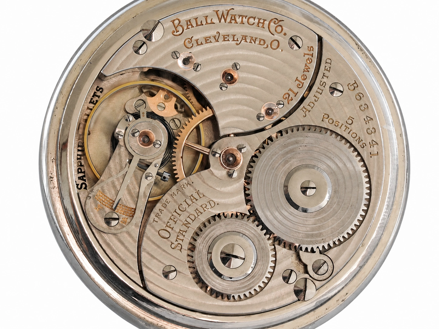 Open movement showing exposed gears, jewels, and engraved plate with maker and serial details.