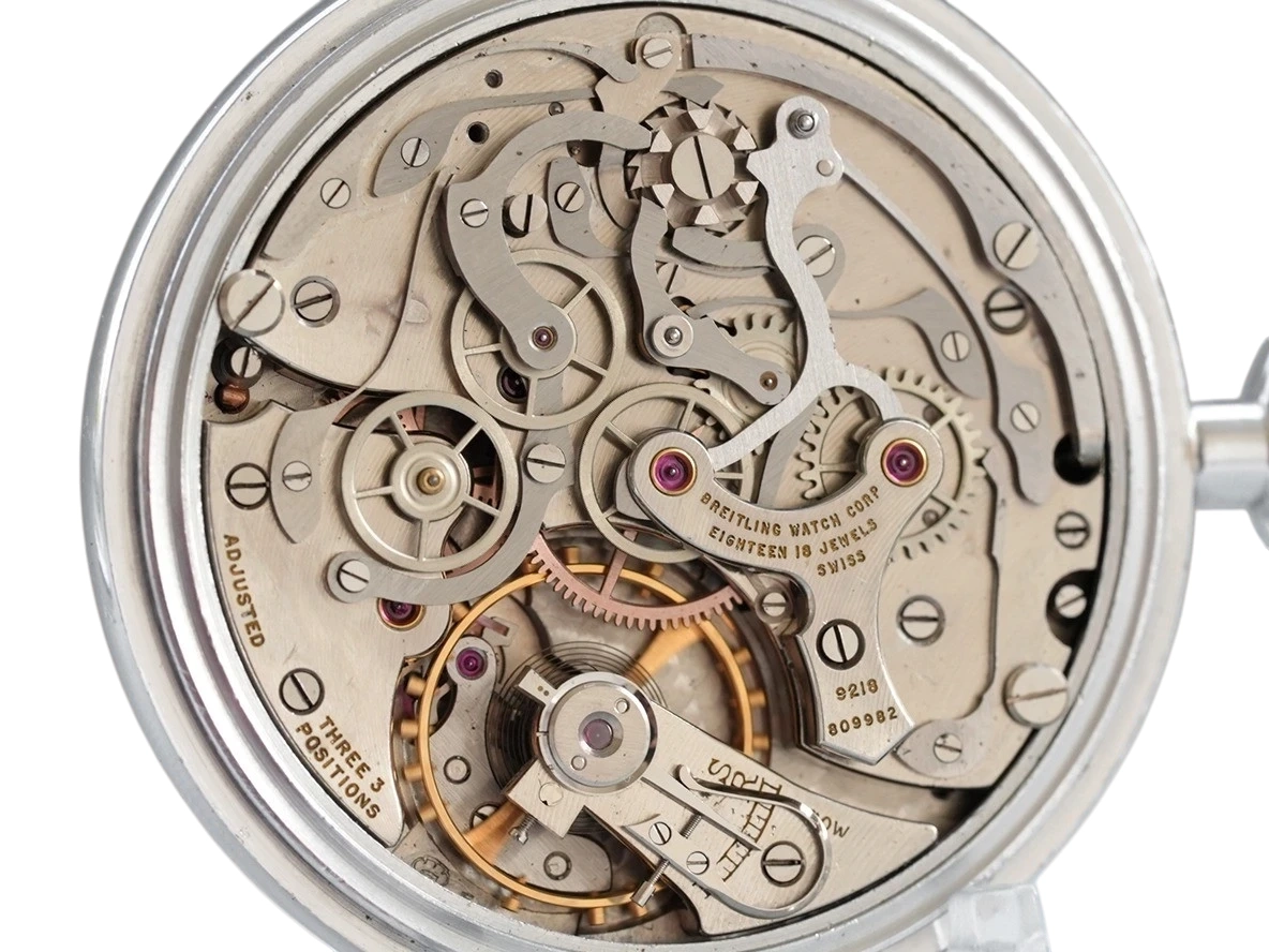 Open movement with jeweled balances, escapement, and gearing visible under metal plate in polished case.