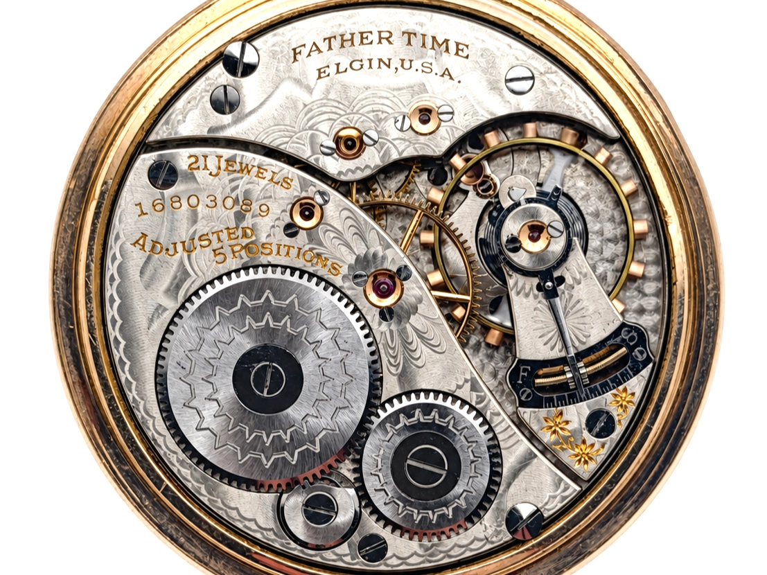 Elgin Father Time Grade 388 — open movement with ornately decorated plates, bridges, and winding wheels, displaying jewels and engraved…