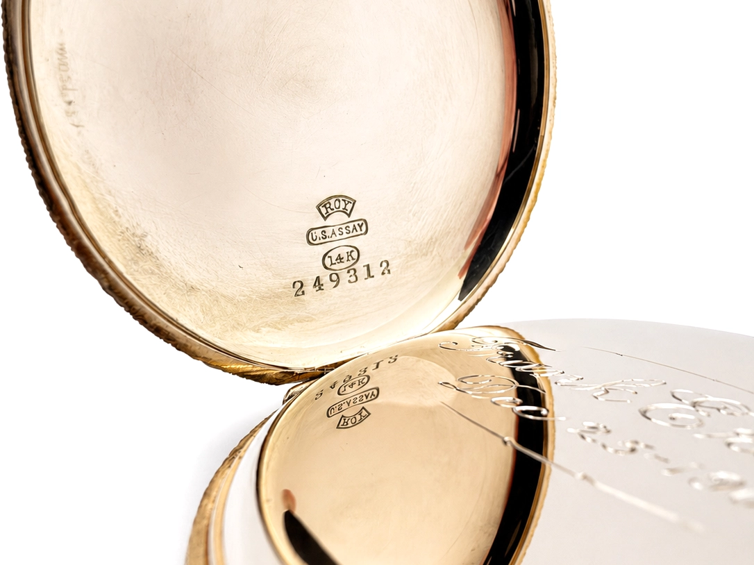 Open case back showing gold interior with hallmarks, U.S. Assay mark, and serial number engraving.