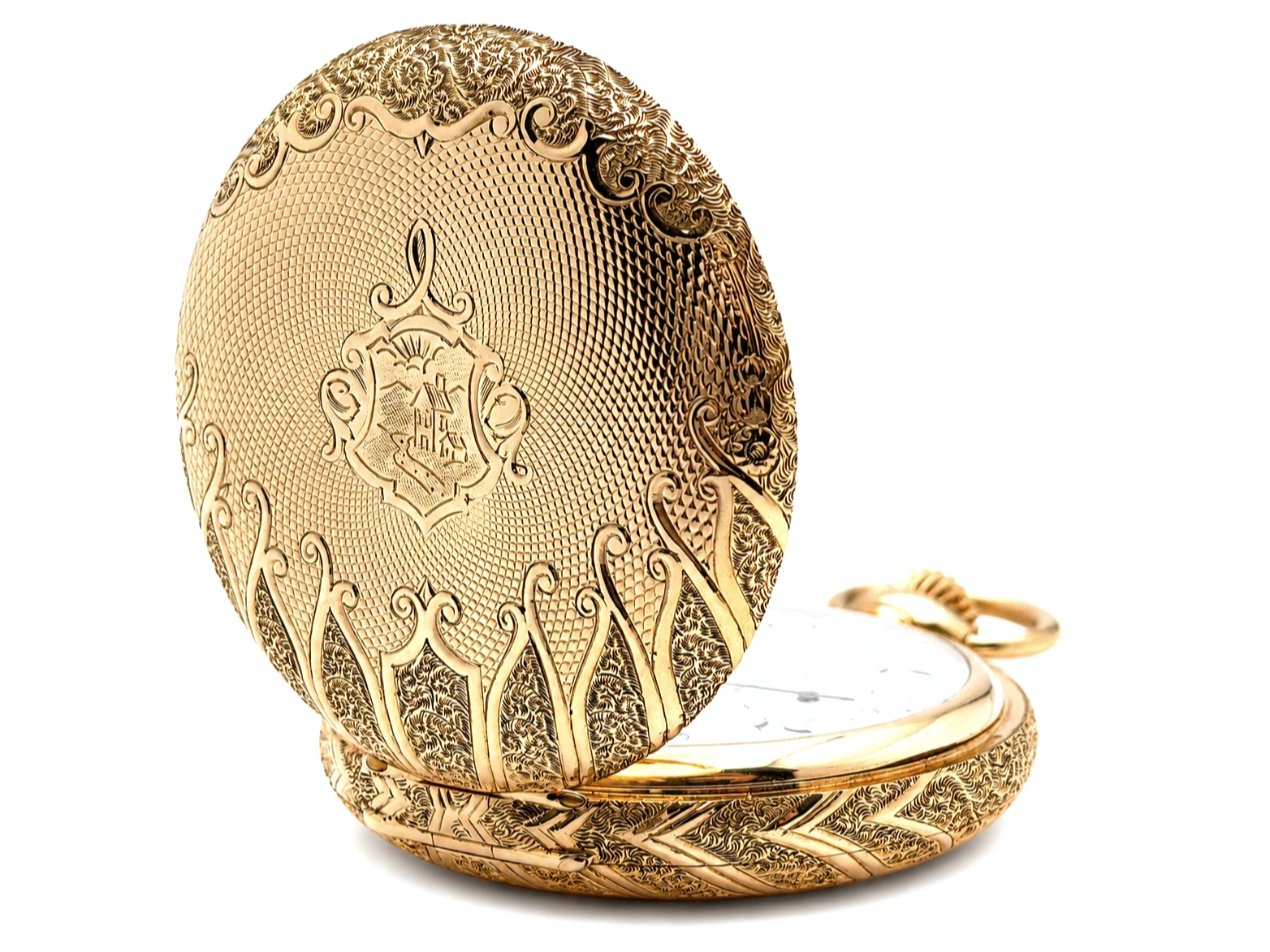 Ornate gold case back with detailed heraldic engraving and foliate scrollwork, open to reveal white enamel dial.