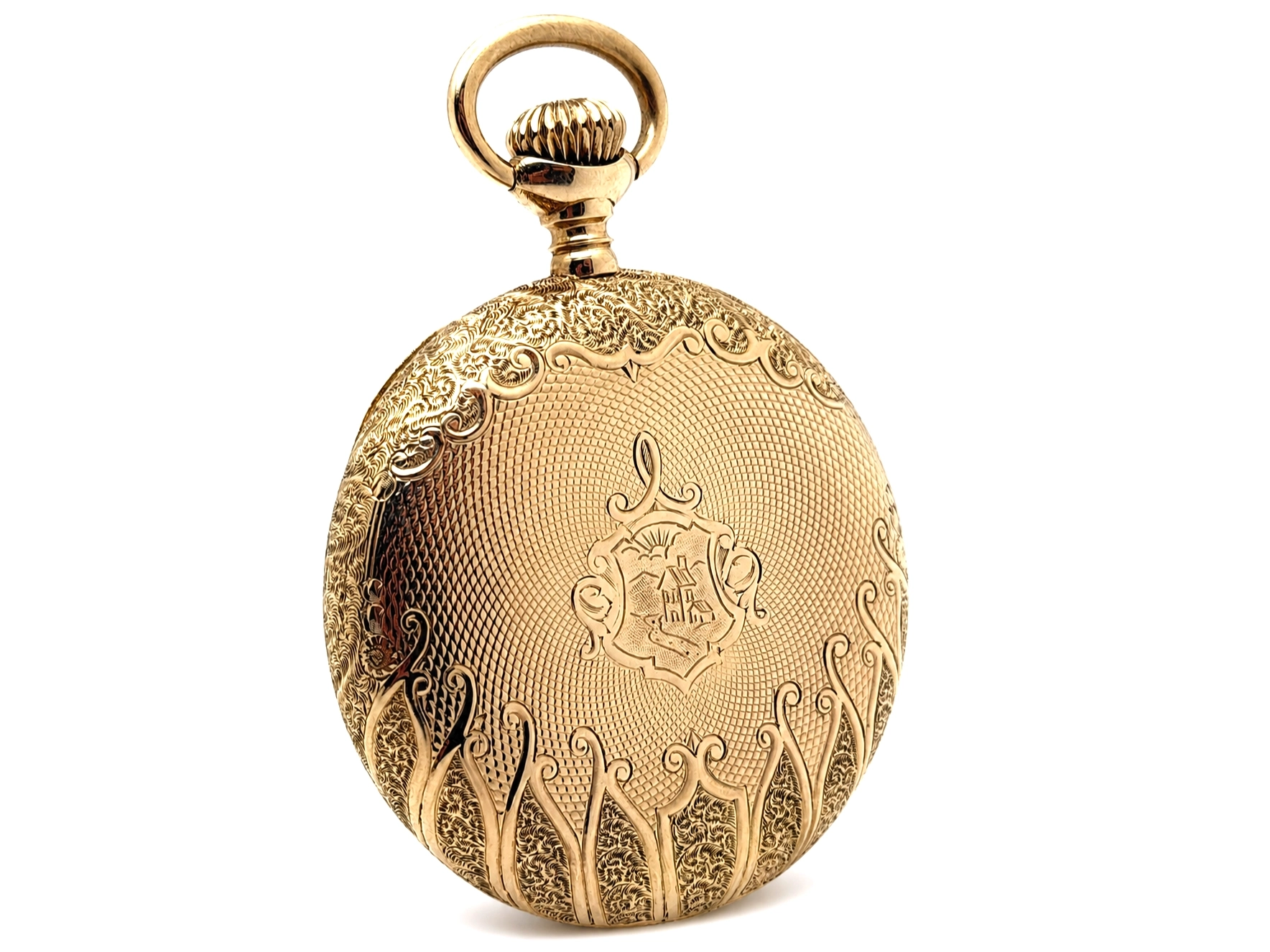 Gold pocket watch case with ornate floral engraving and decorative crest in center.