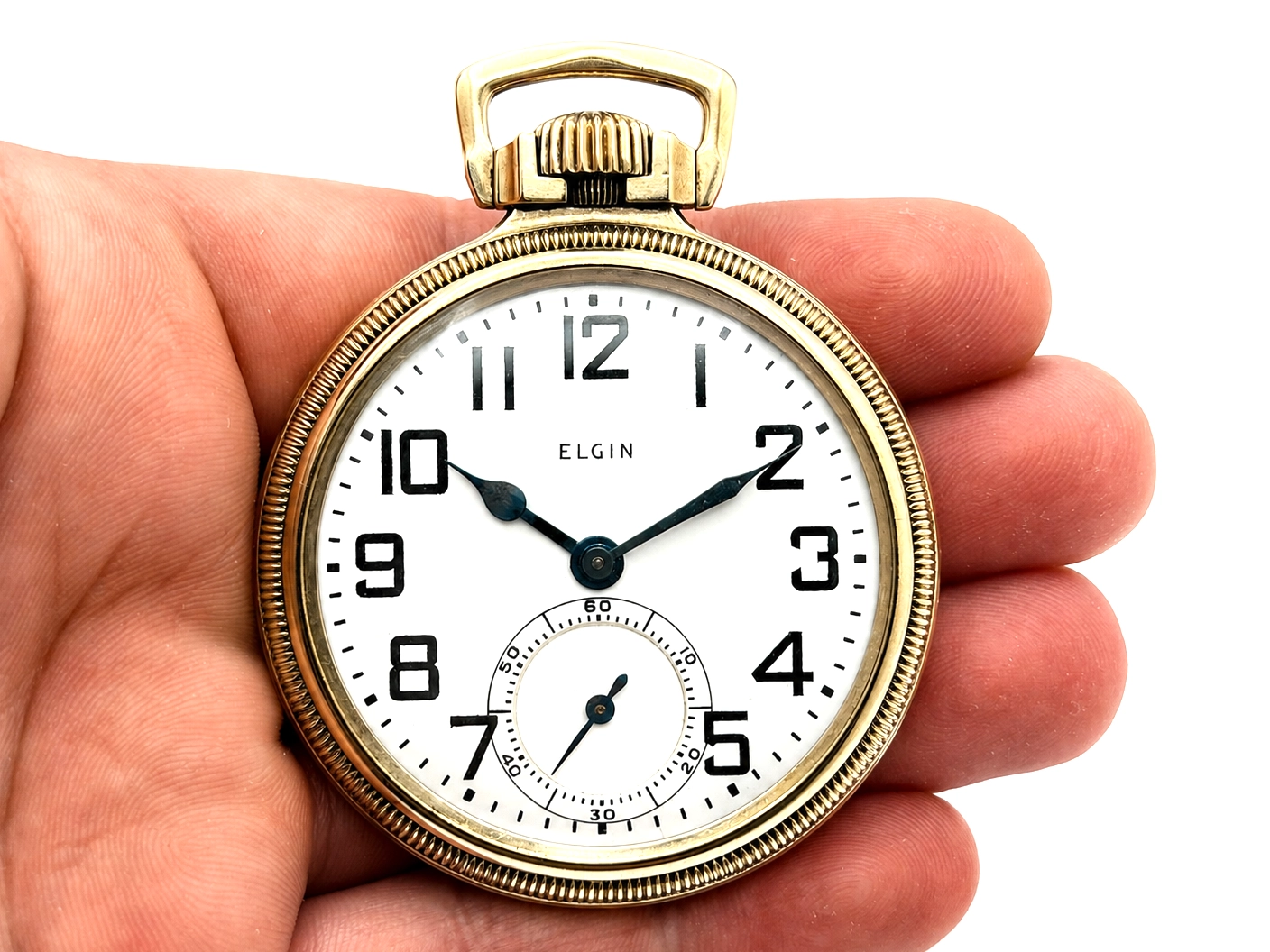 Gold-tone Elgin pocket watch with white dial, black Arabic numerals, and subsidiary seconds dial.