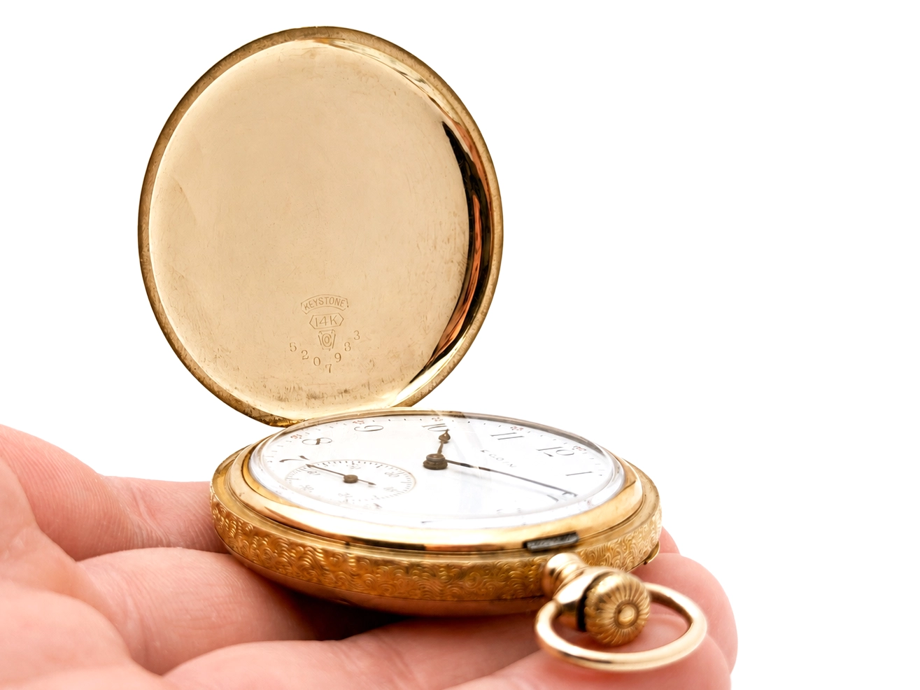 Open gold pocket watch showing white enamel dial with numerals and movement visible inside case.