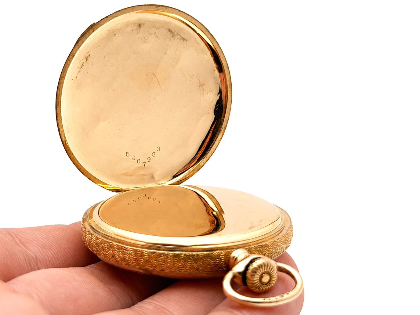 Open gold pocket watch case showing interior back plate with visible hallmarks and serial number.