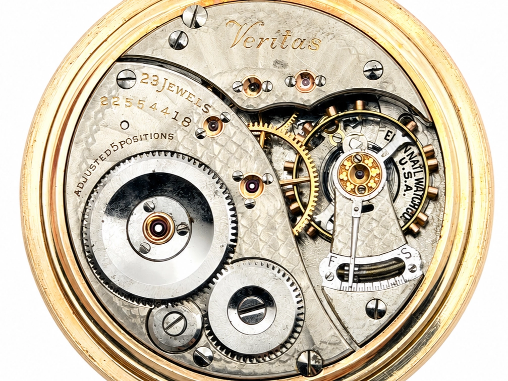 Elgin Veritas 453 Up/Down Wind (1920) — open movement showing 23-jewel escapement, balance wheel, and decorated gilt wheels with visible…