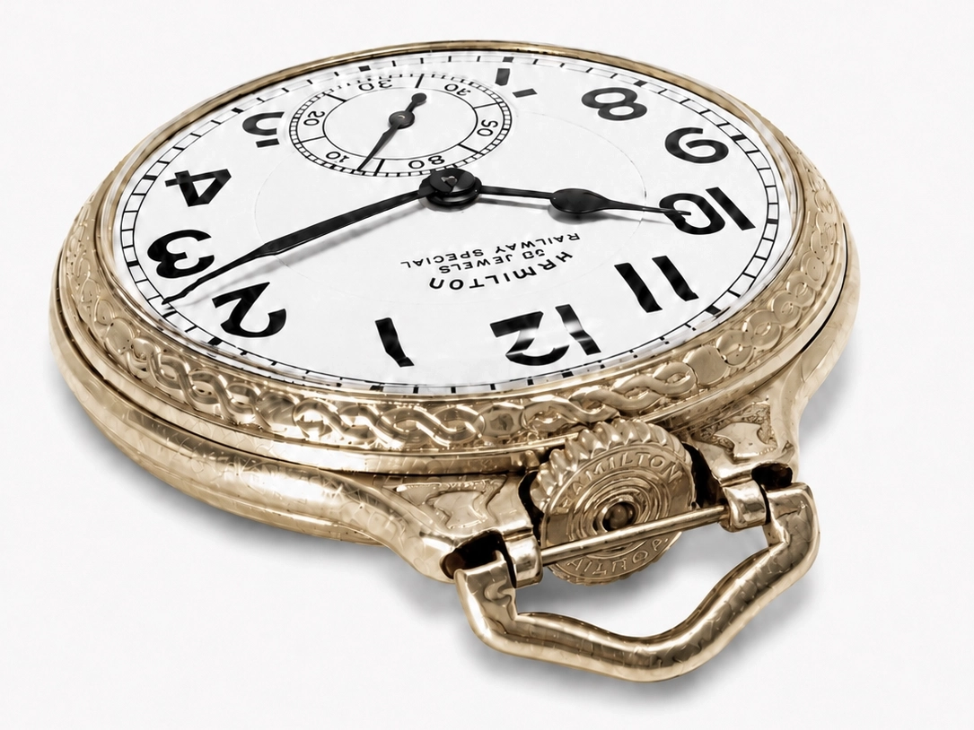 Gold-toned open-face pocket watch with white dial, bold Arabic numerals, subsidiary dial, and ornamental case with attached chain loop.