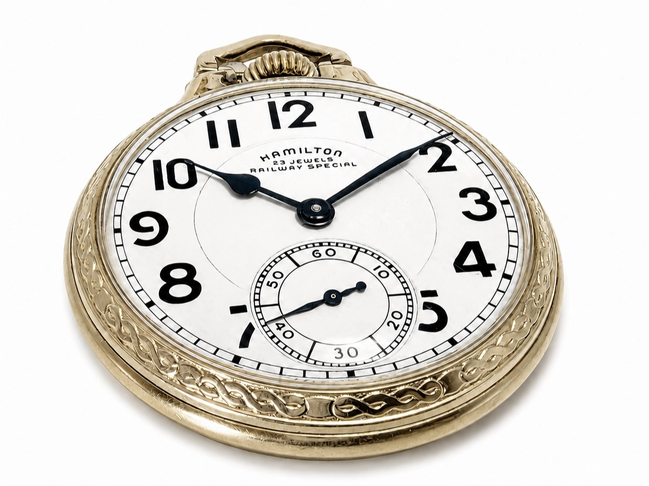 Gold pocket watch with white dial, black Arabic numerals, subsidiary seconds dial, and ornate engraved case.