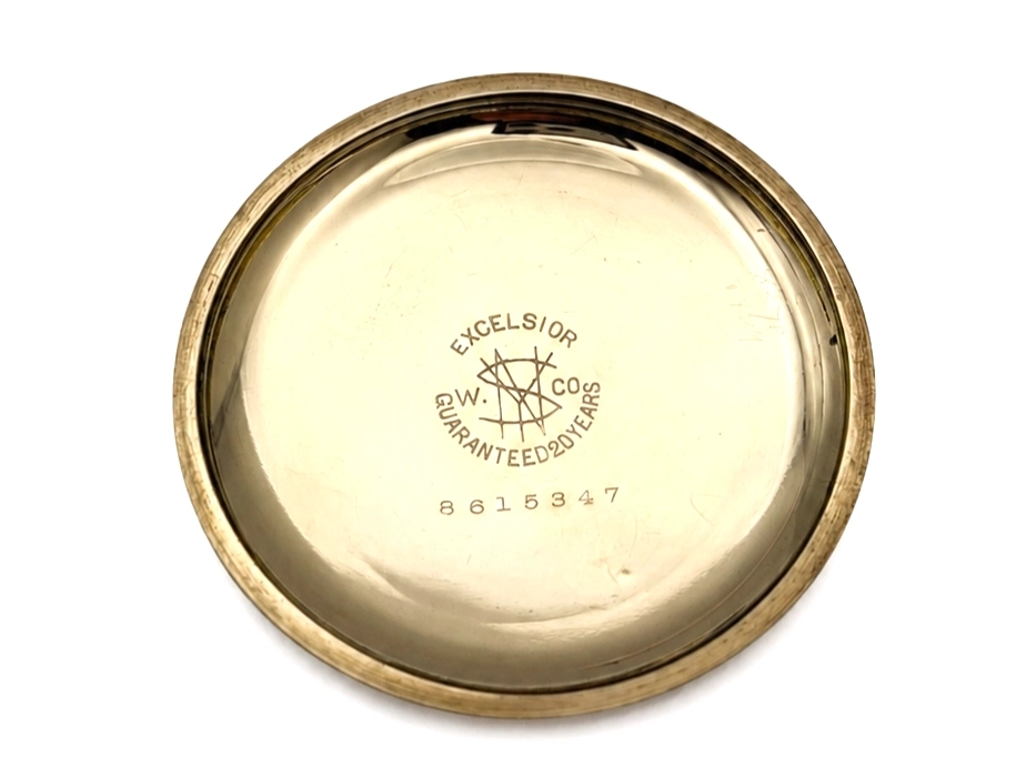 Pocket watch case back showing Excelsior maker hallmark, "Guaranteed 20 Years" text, and serial number 8615347.