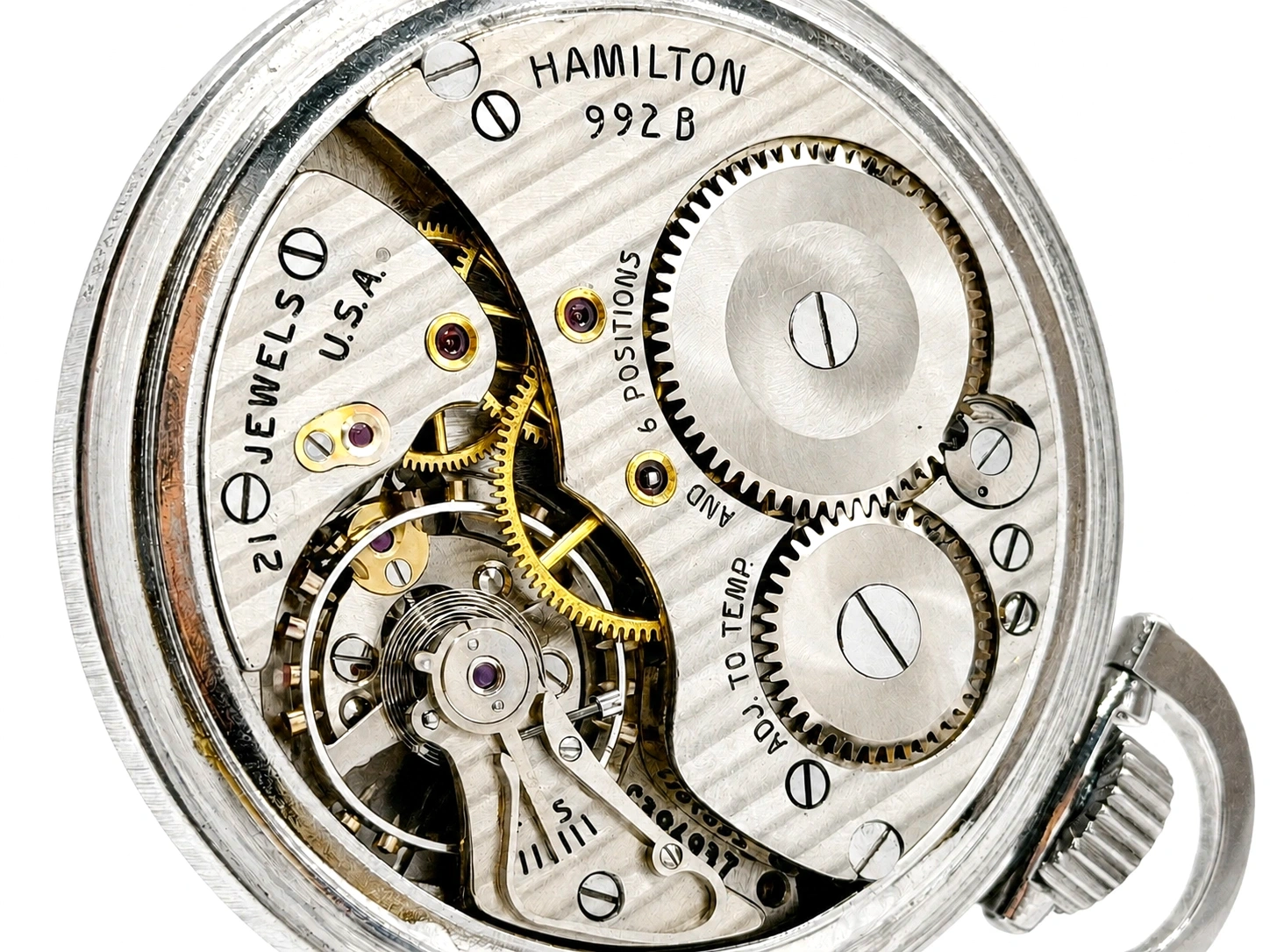 Hamilton pocket watch movement showing brass gears, jeweled settings, and balance wheel through open caseback.