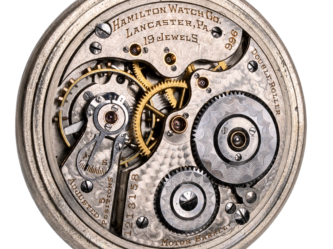 Open pocket watch movement showing 19 jewels, golden gears, and hairspring with Hamilton markings.