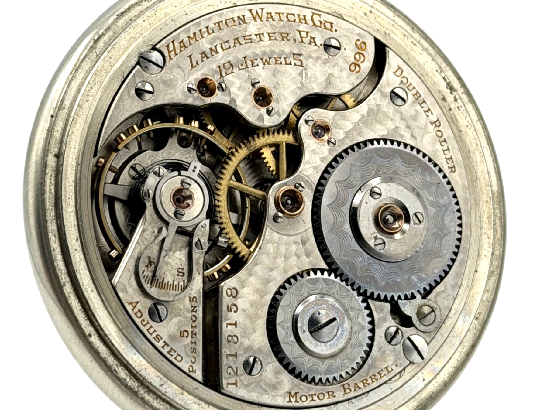 Open movement showing balance wheel, jewels, and gears with Hamilton Watch Co. Lancaster, PA hallmark.