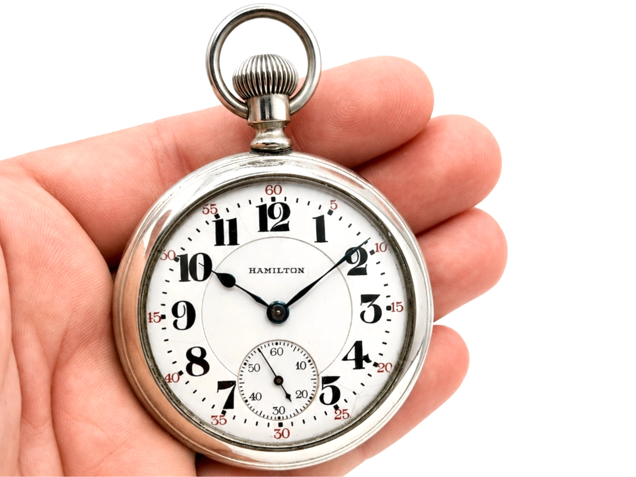 Open face pocket watch with white dial, Arabic numerals, subsidiary seconds dial, and black hands.