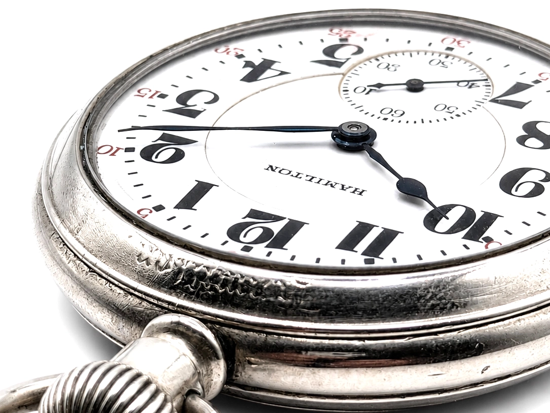 Vintage pocket watch with white dial, Arabic numerals, chronograph subdials, and black hands.