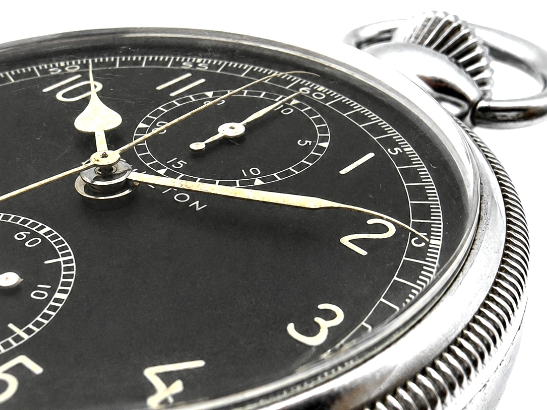 Black dial chronograph with luminous hands, Arabic numerals, subdial, and ribbed metal case with crown.