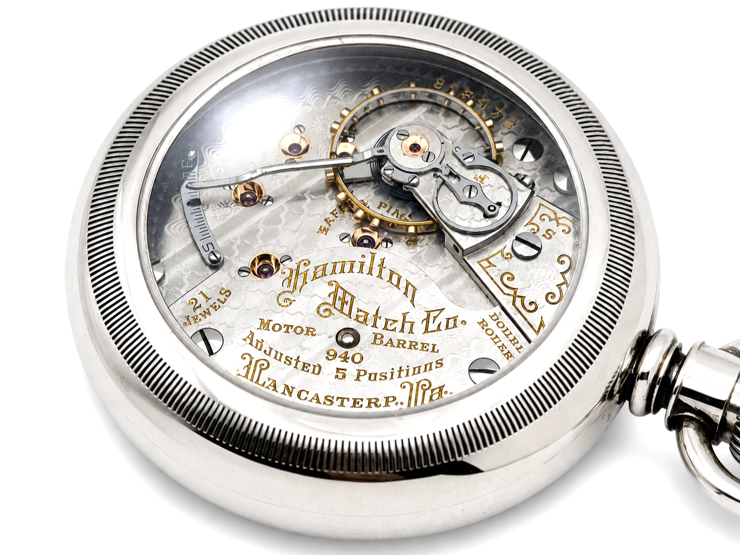 Open pocket watch case revealing exposed movement with barrel, balance wheel, and jeweled components.
