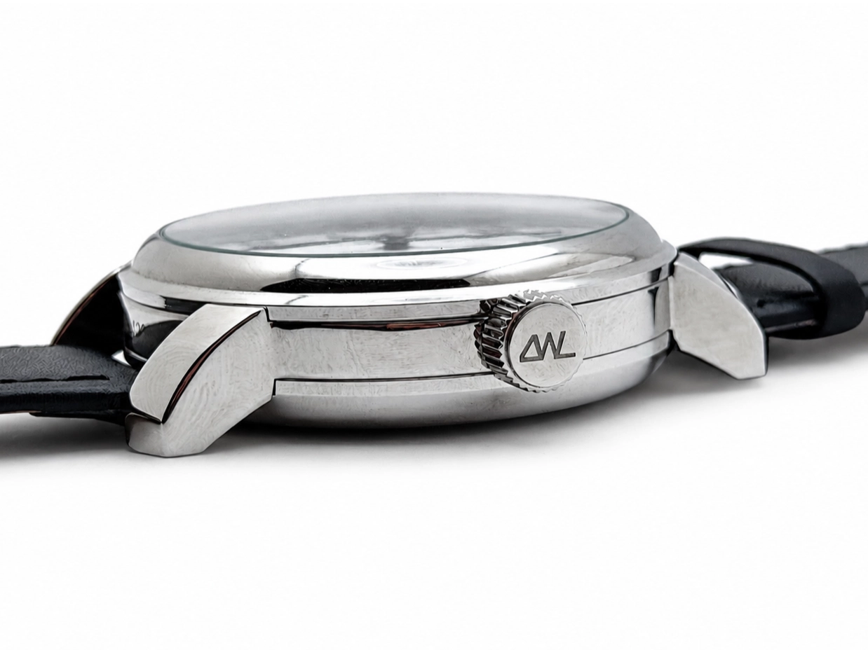 Side profile of polished steel watch case with crown detail and black leather strap.