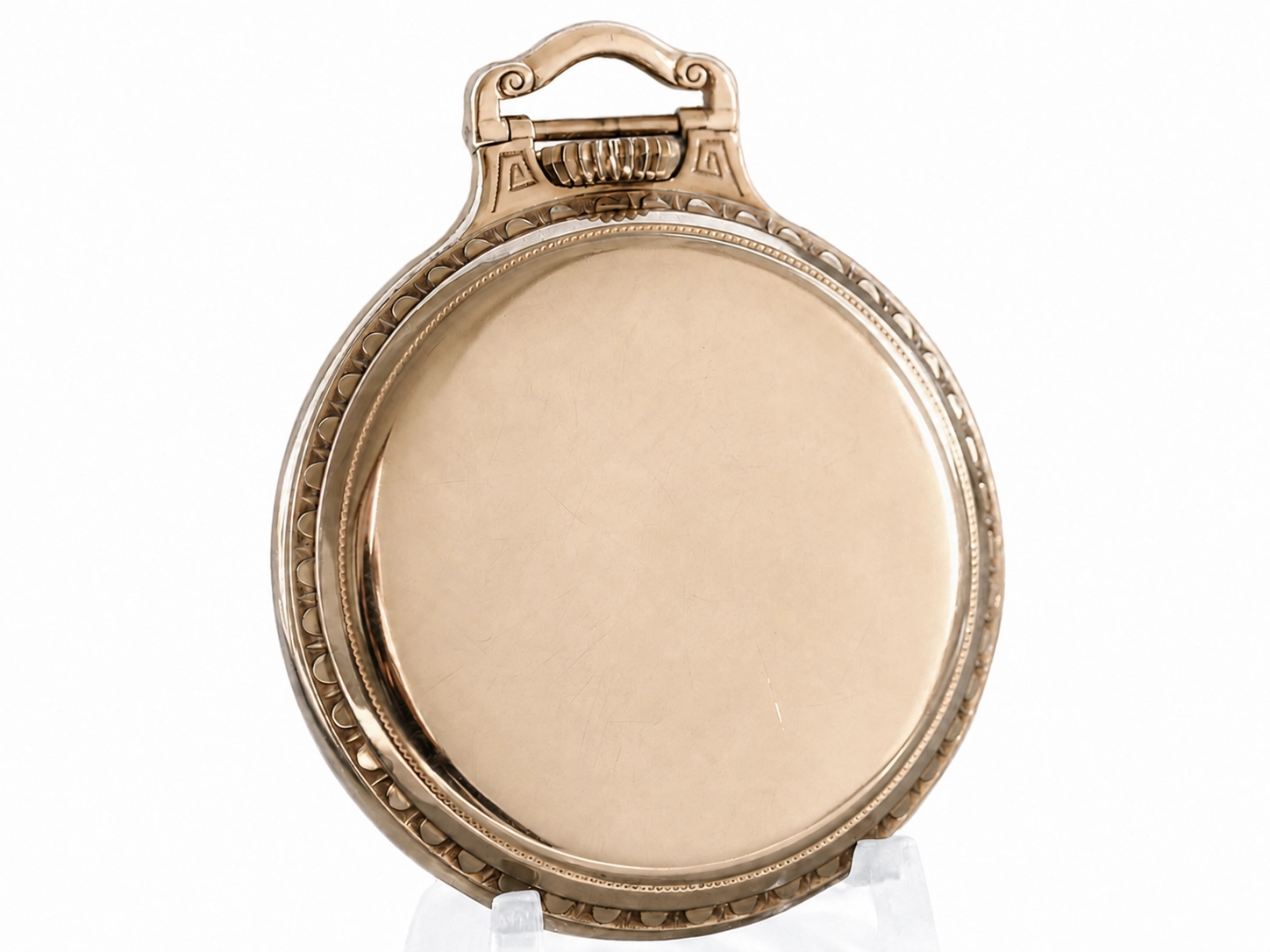 Polished pocket watch case back with ornate scrollwork, decorative bail, and beaded edge border.
