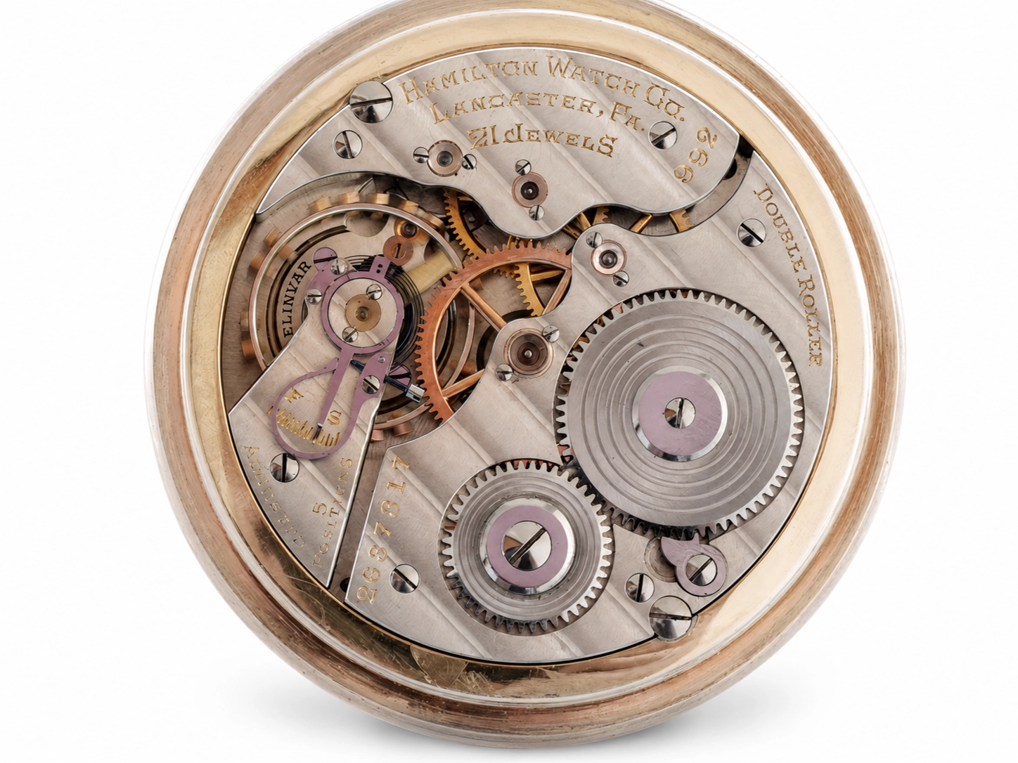 Open movement showing gears, jeweled plates, and gold-colored balance wheel with engraved Hamilton Watch Co. mainplate.