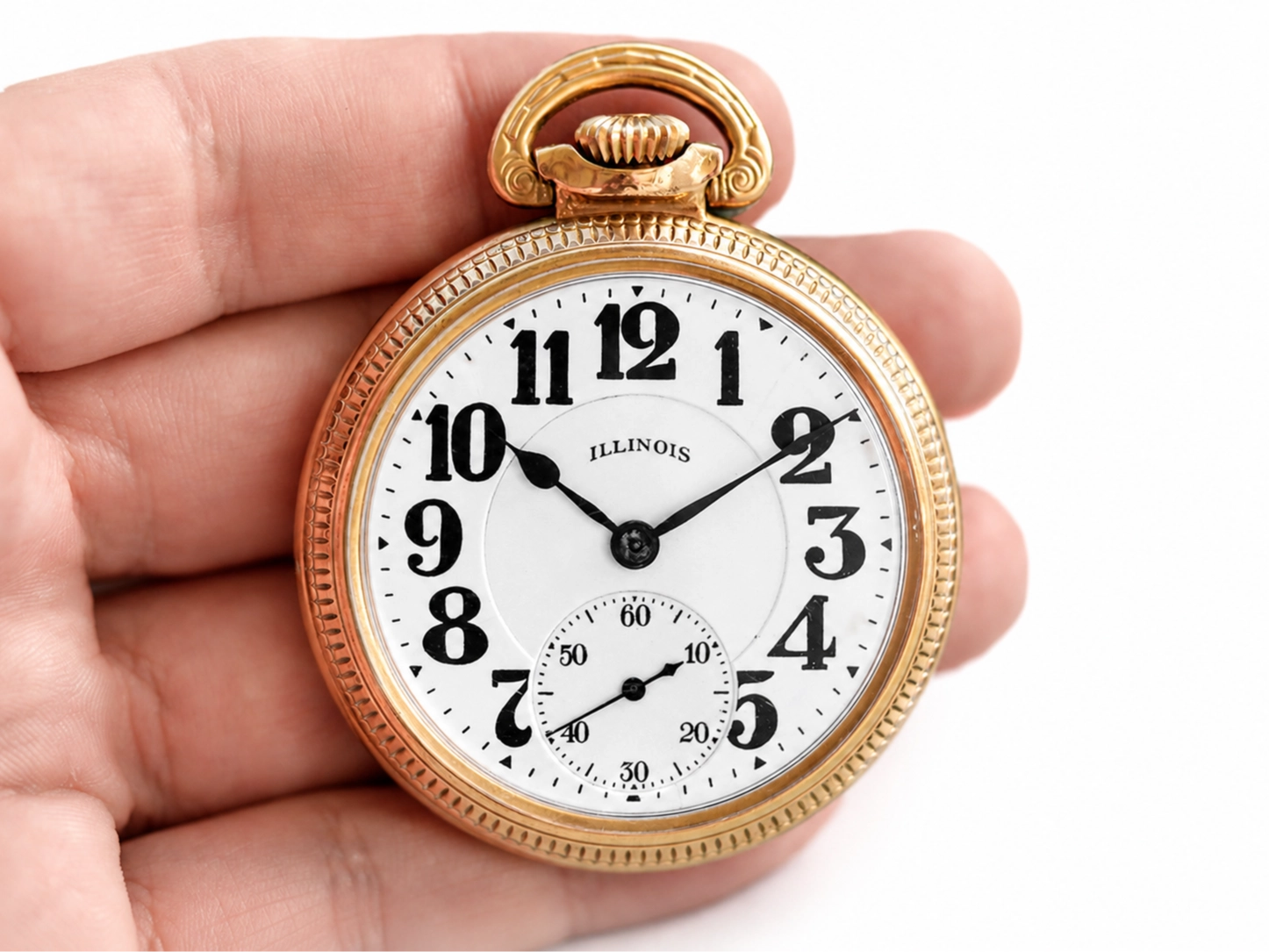 Gold pocket watch with white dial, bold black Arabic numerals, subsidiary seconds dial, and black hands.