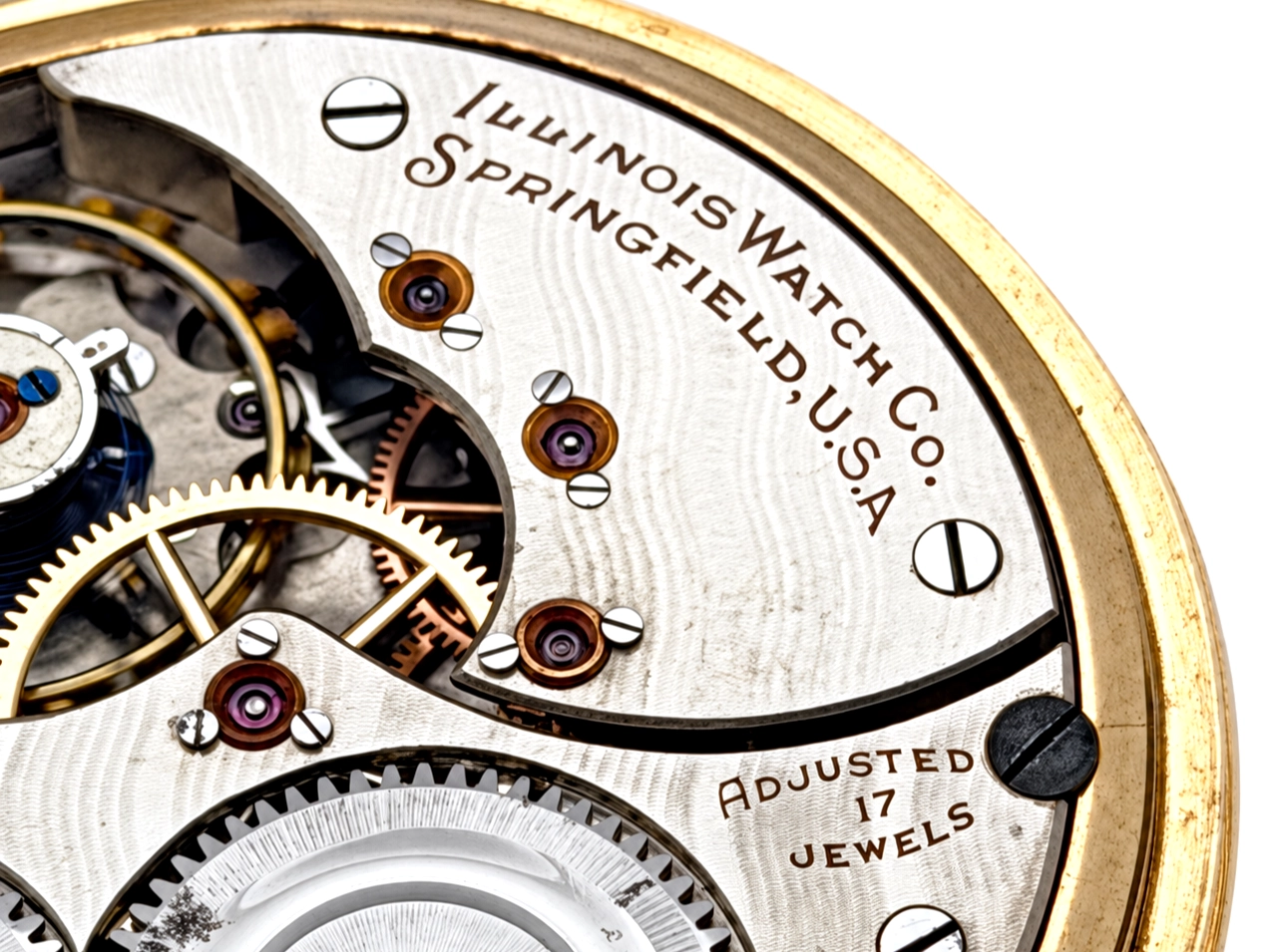 Illinois Dress 605 (1921) — open movement showing decorated wheels, ruby jewels, and "ADJUSTED 17 JEWELS" engraving