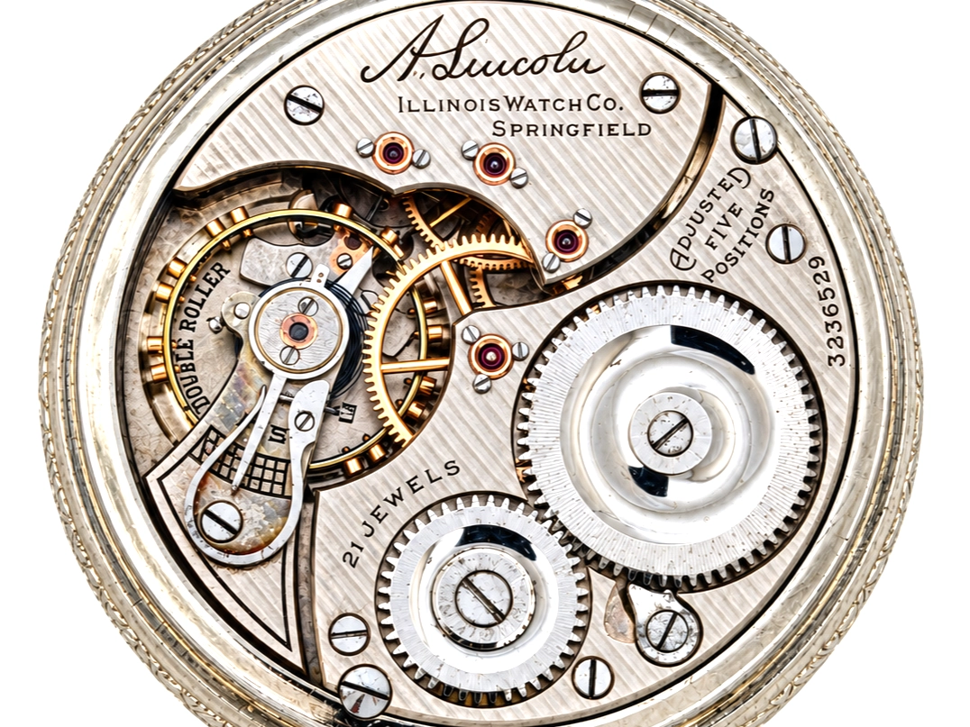 Illinois A. Lincoln White GF Wadsworth Case (1917) — open movement with balance wheel, jeweled settings, gear wheels, and decorated…