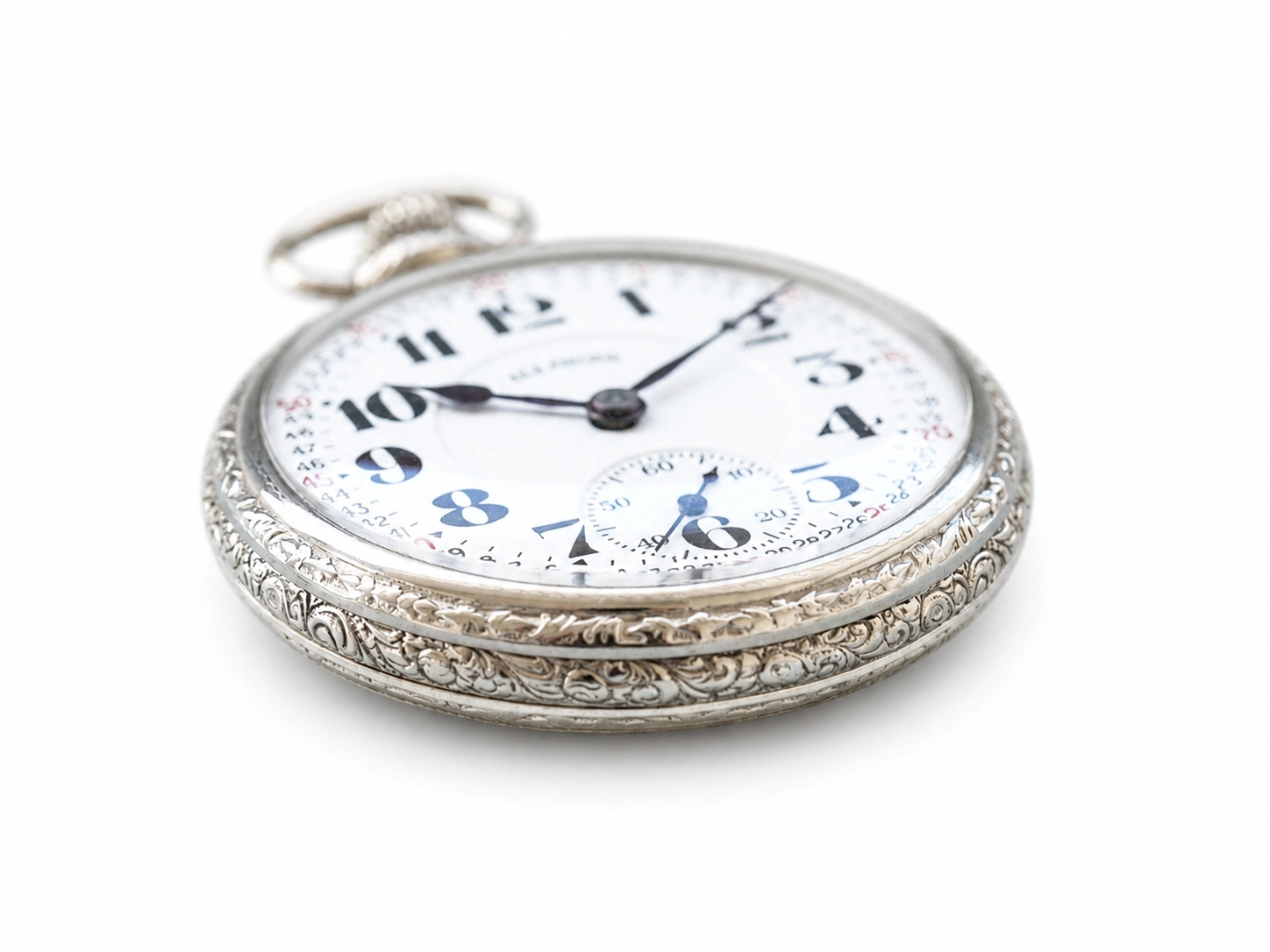 Silver pocket watch with ornate filigree case, white dial with Arabic numerals, and subsidiary seconds dial.