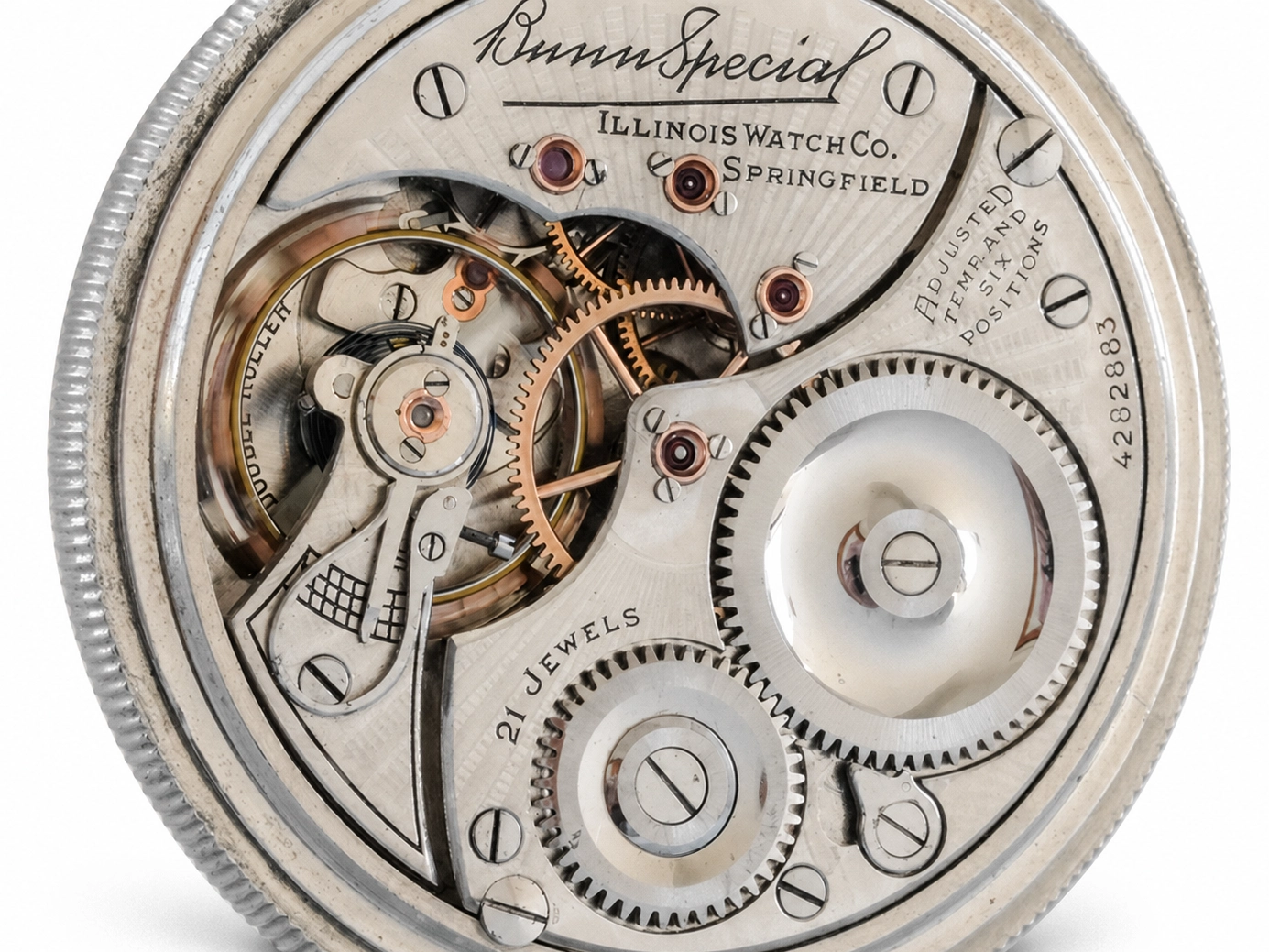 Open pocket watch movement showing balance wheel, brass gears, and jewel settings with Illinois Watch Co. Springfield dial.