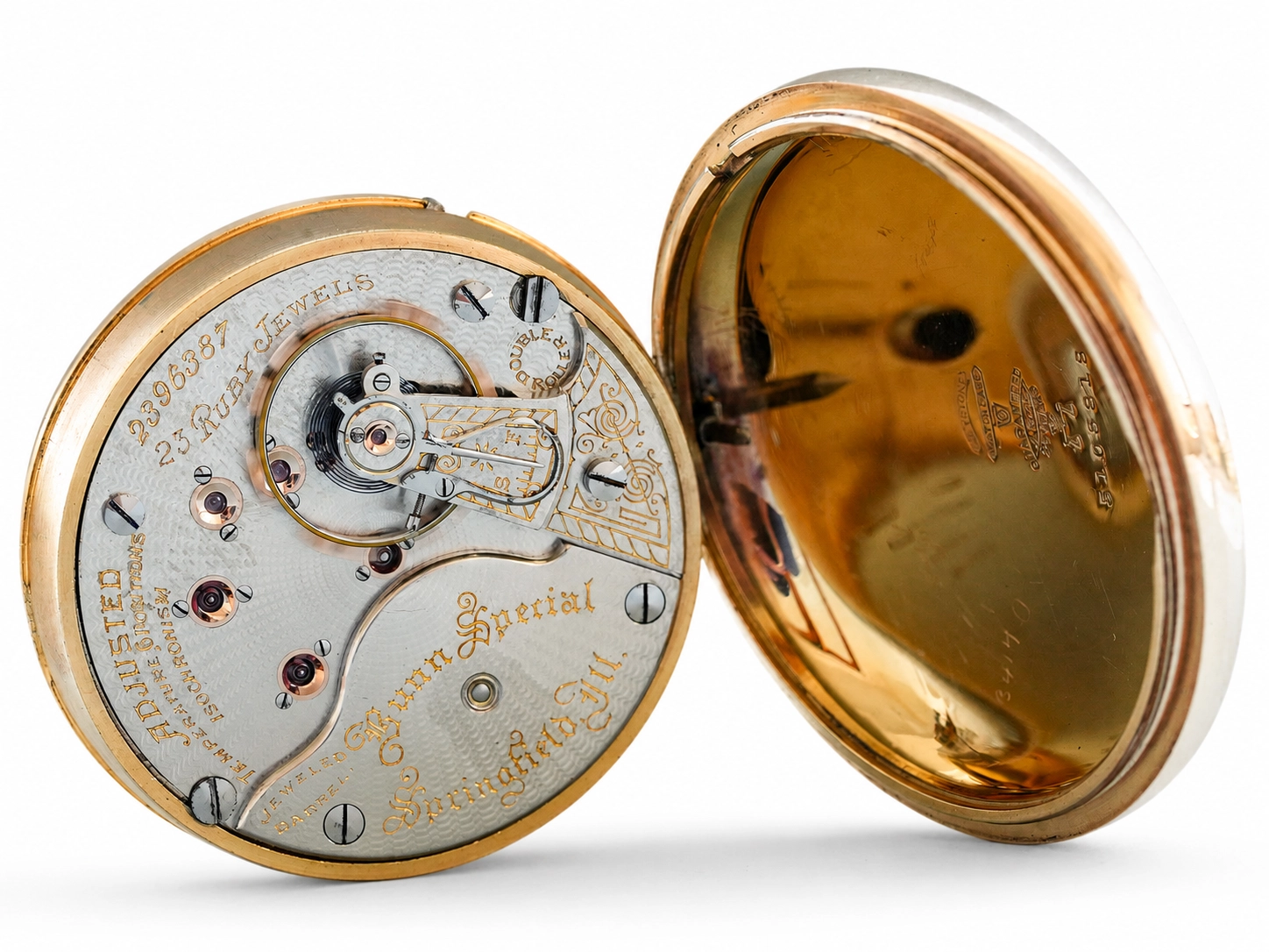 Open pocket watch showing ornate silvered movement with jewels and balance wheel in gold case.