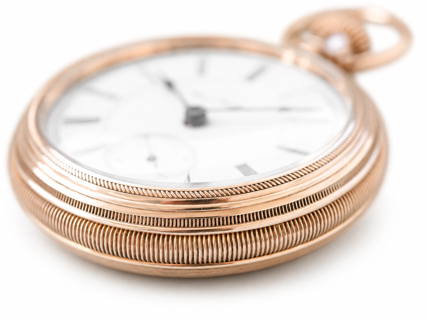 Rose gold pocket watch with white dial, Roman numerals, and deeply fluted case design.