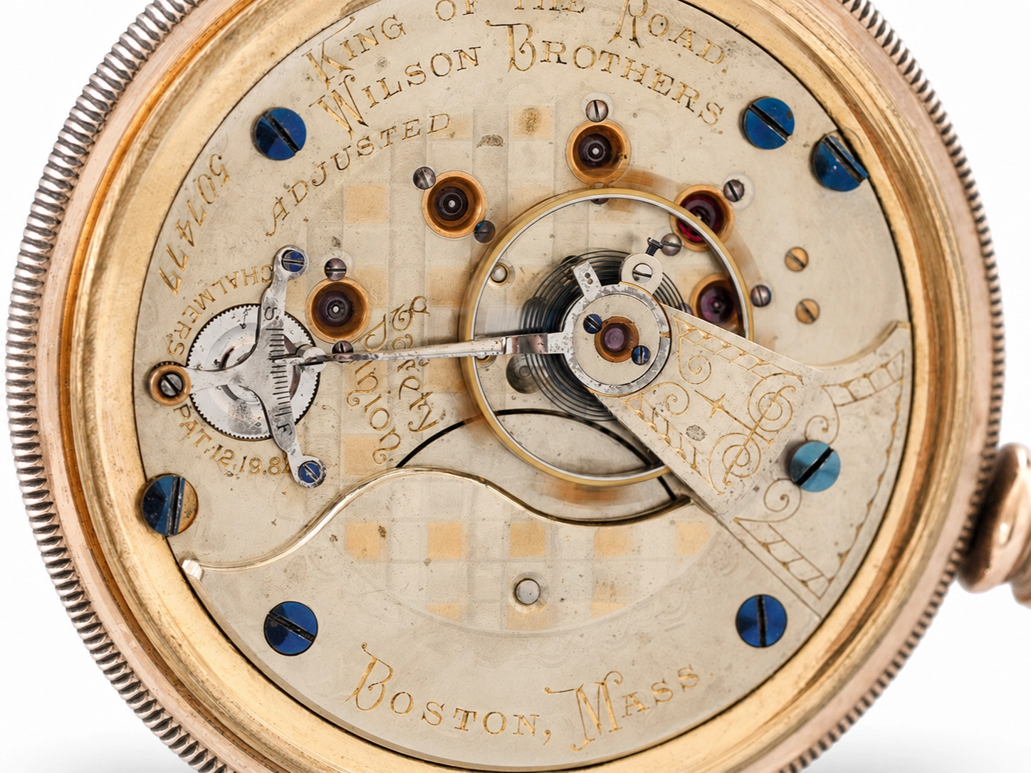 Open case back showing movement with blue jewels, gold-filled plates, and engraved maker details.