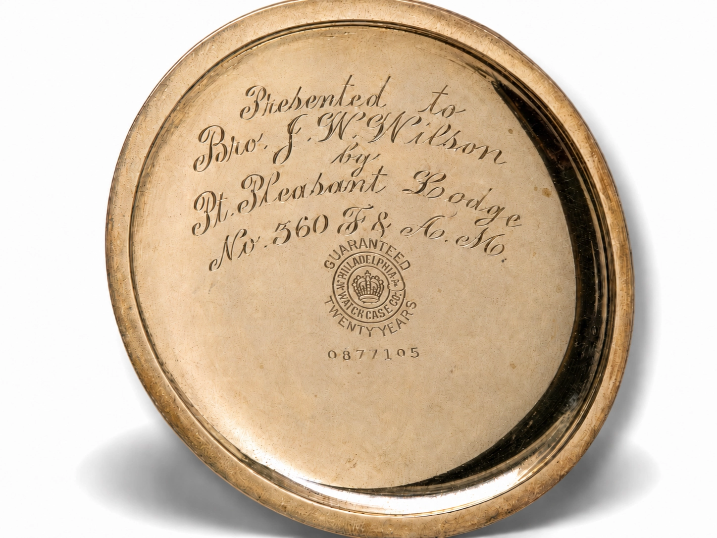 Gold case back engraved with presentation inscription, guarantee hallmark, and serial number 0877105.