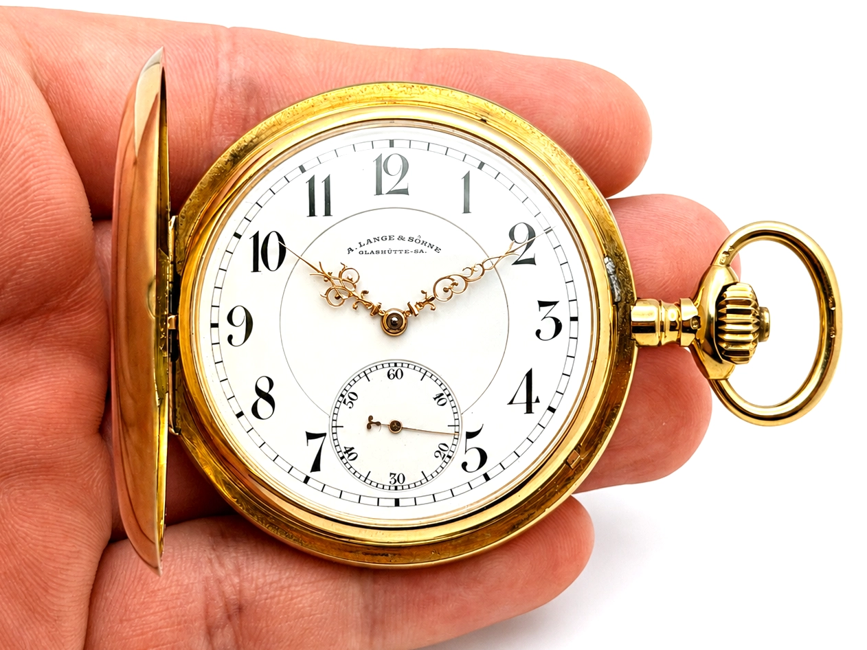 Gold hunter case pocket watch with white enamel dial, Arabic numerals, and subsidiary seconds dial.