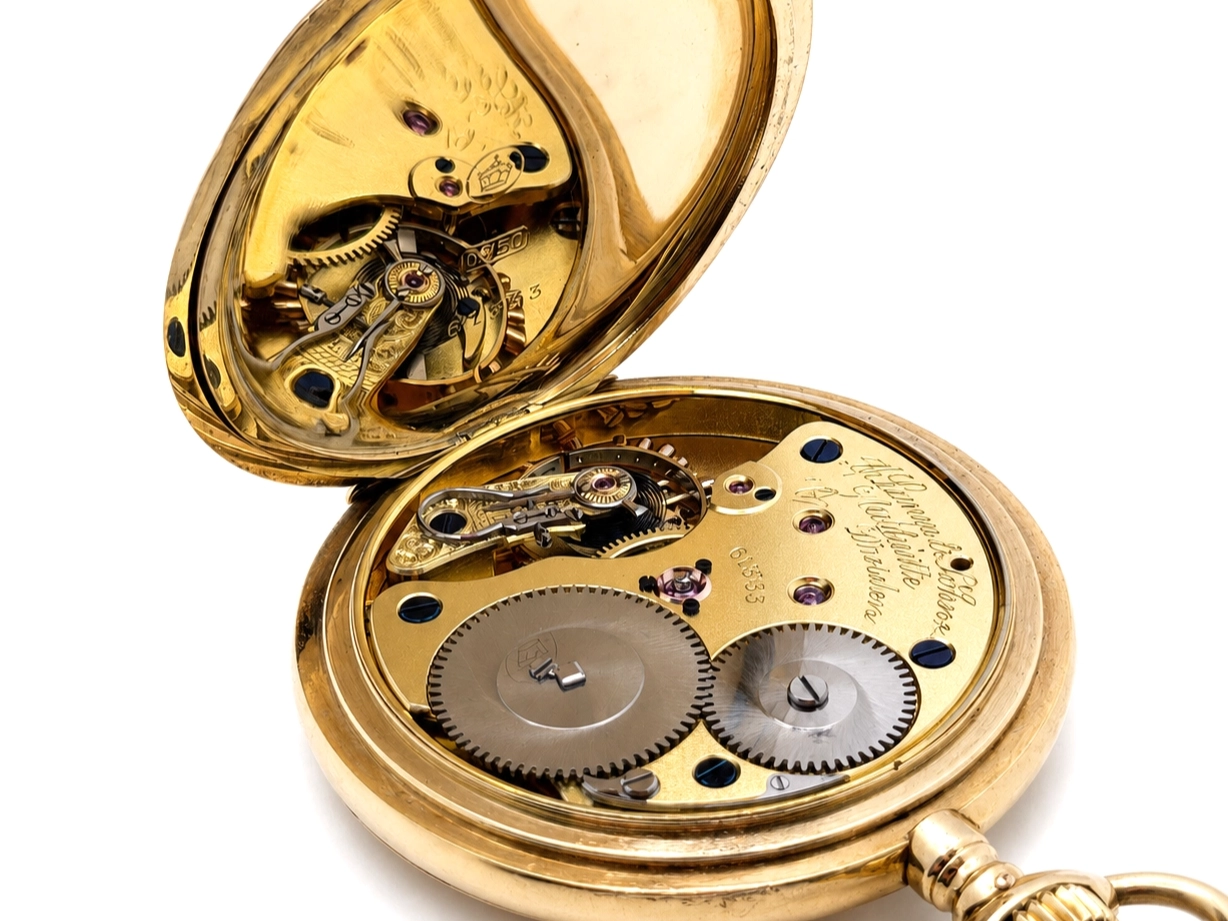 Open pocket watch showing gilt movement with jeweled bearings and large gear wheels beneath the balance cock.