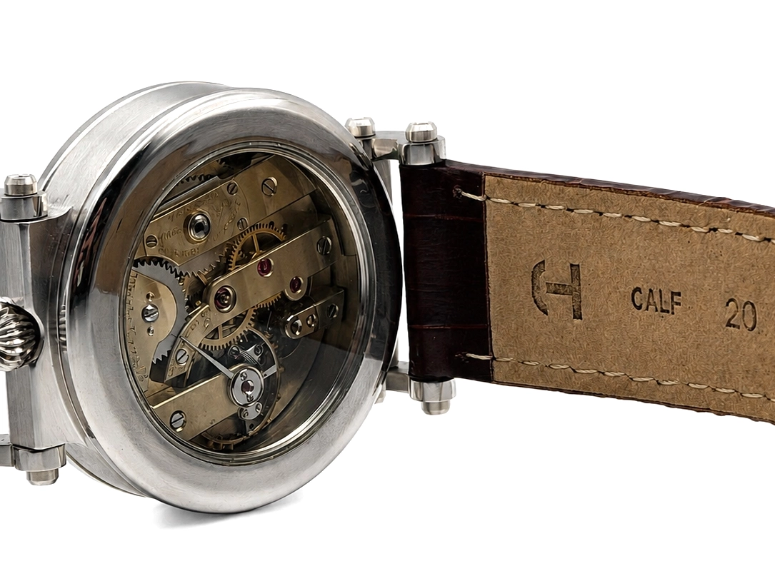 Watch with open movement visible through crystal, polished steel case, brown leather strap with calf marking.