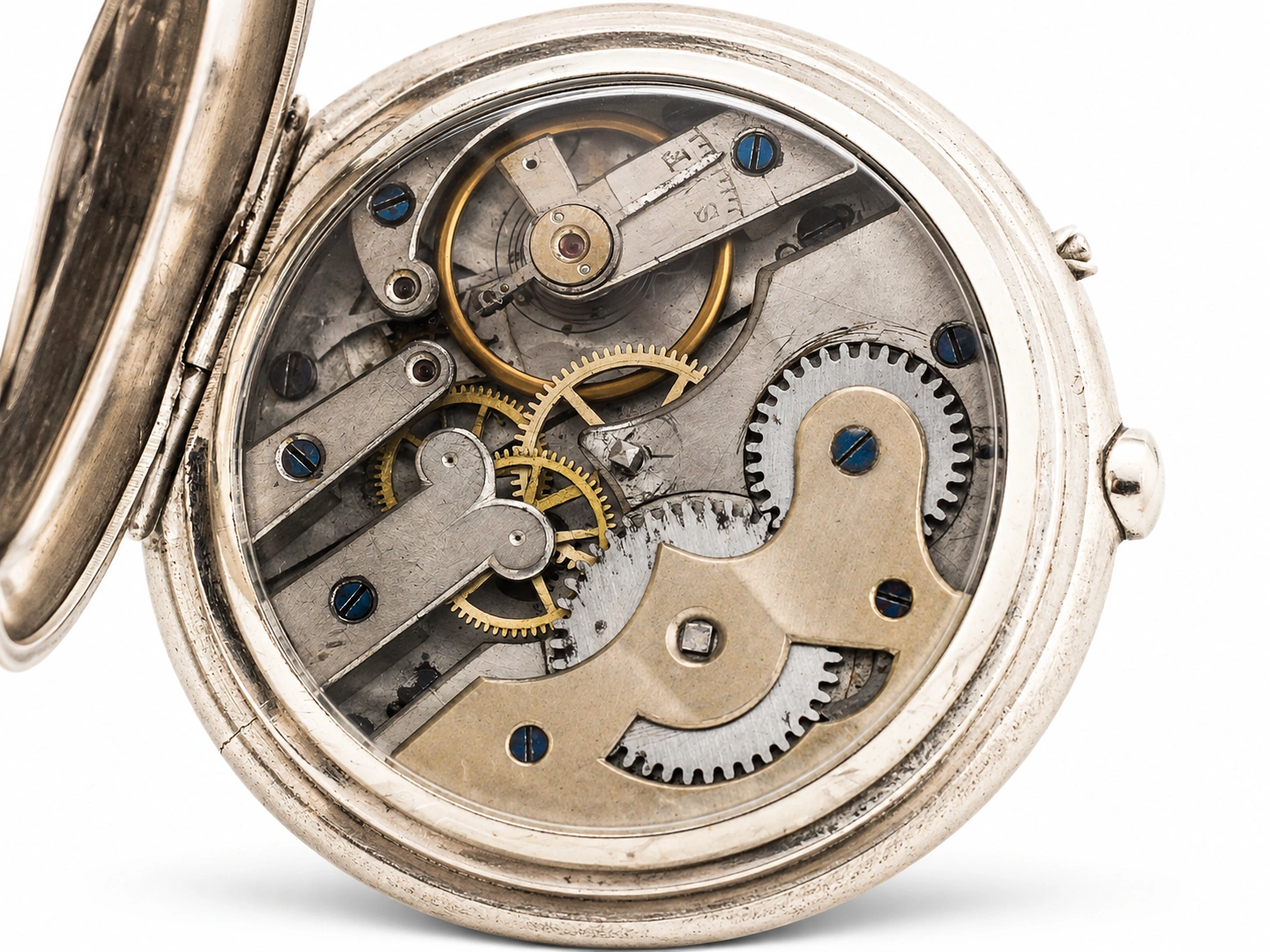 Open pocket watch movement showing brass gears, jewels, and blue screws in silver case.