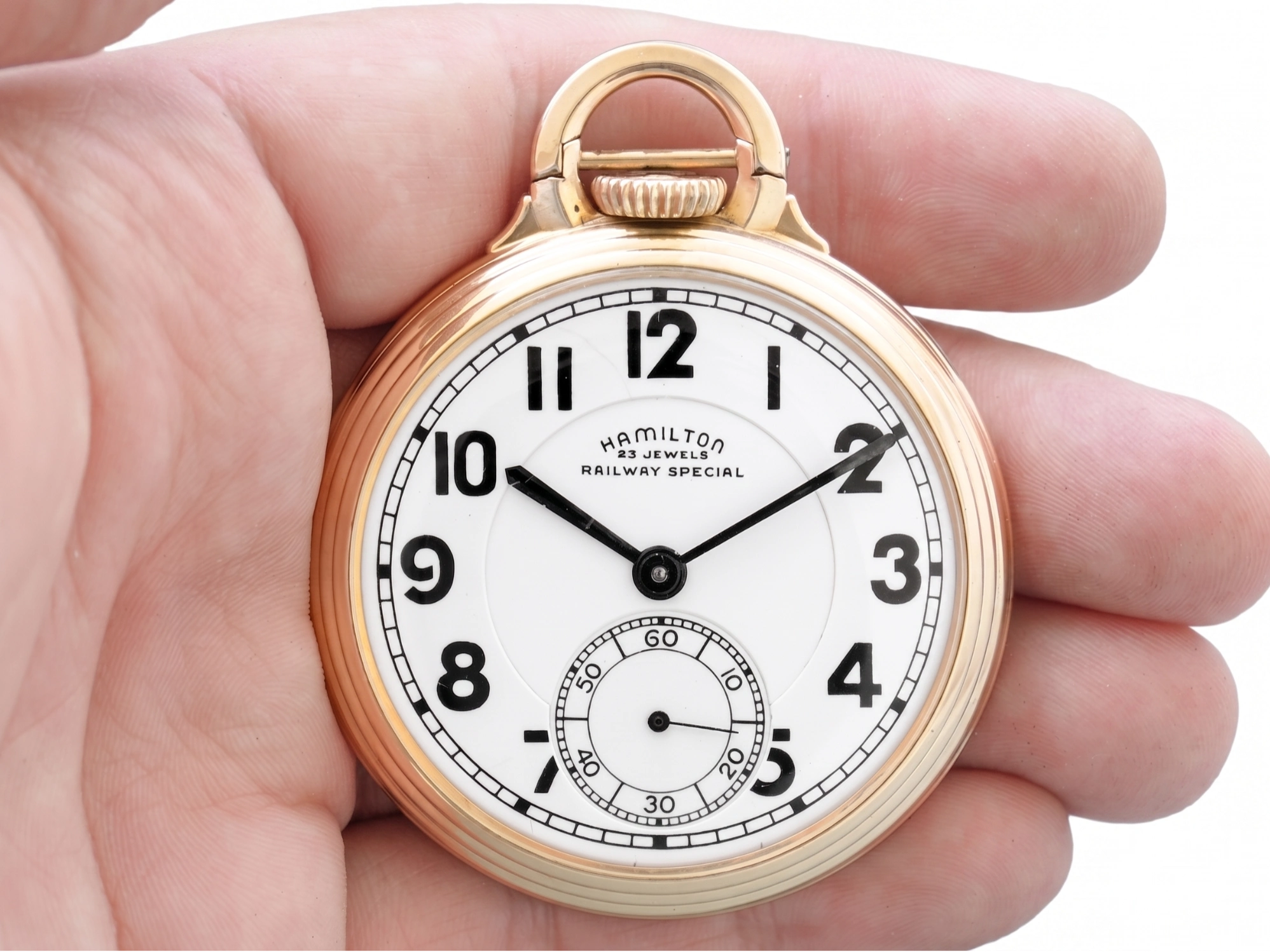 Rose gold pocket watch with white dial, Arabic numerals, subdial, and "Railway Special" text visible.