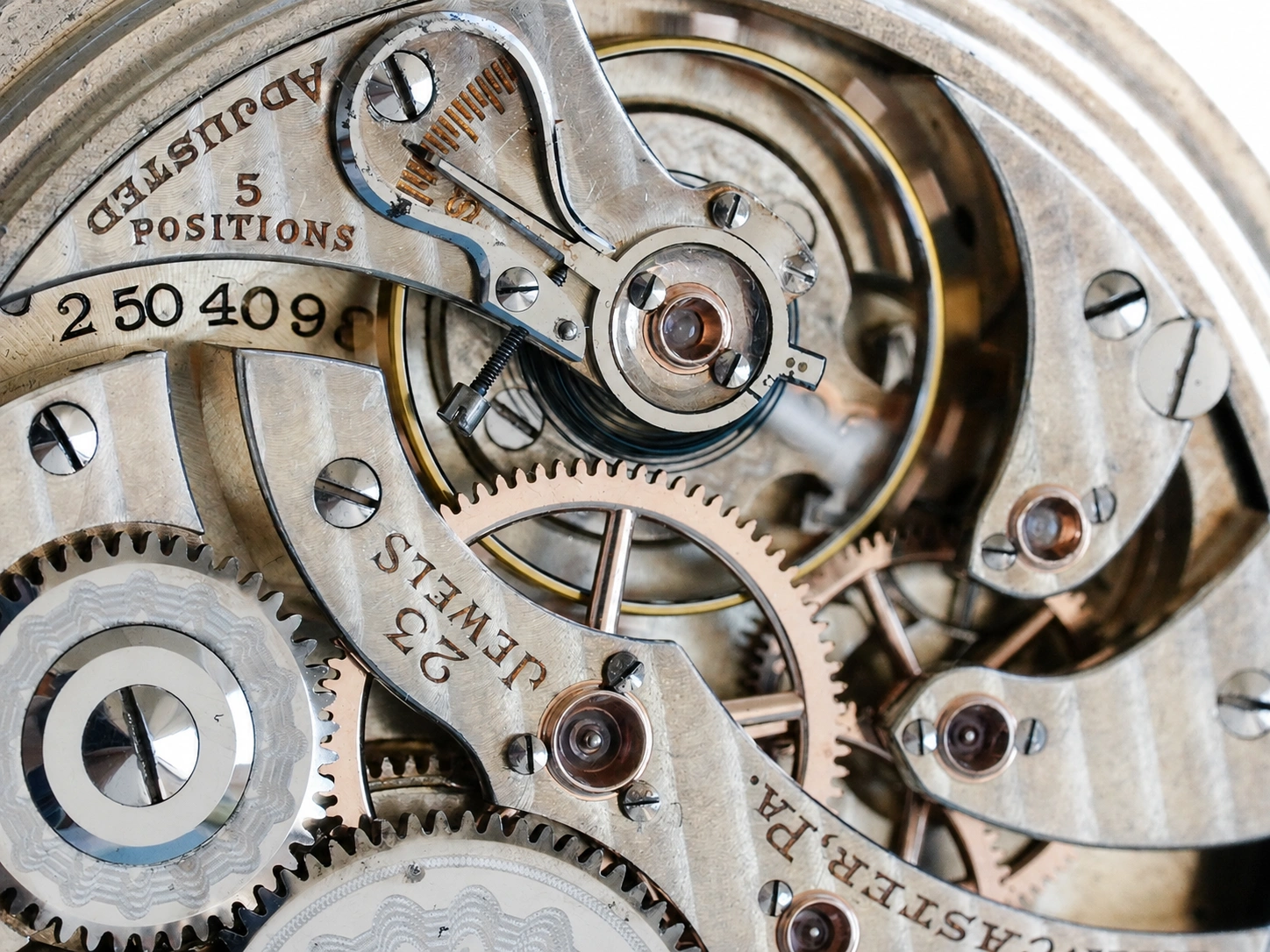 Internal movement with visible gears, jewel bearings, and steel balance wheel assembly in exposed chronograph mechanism.