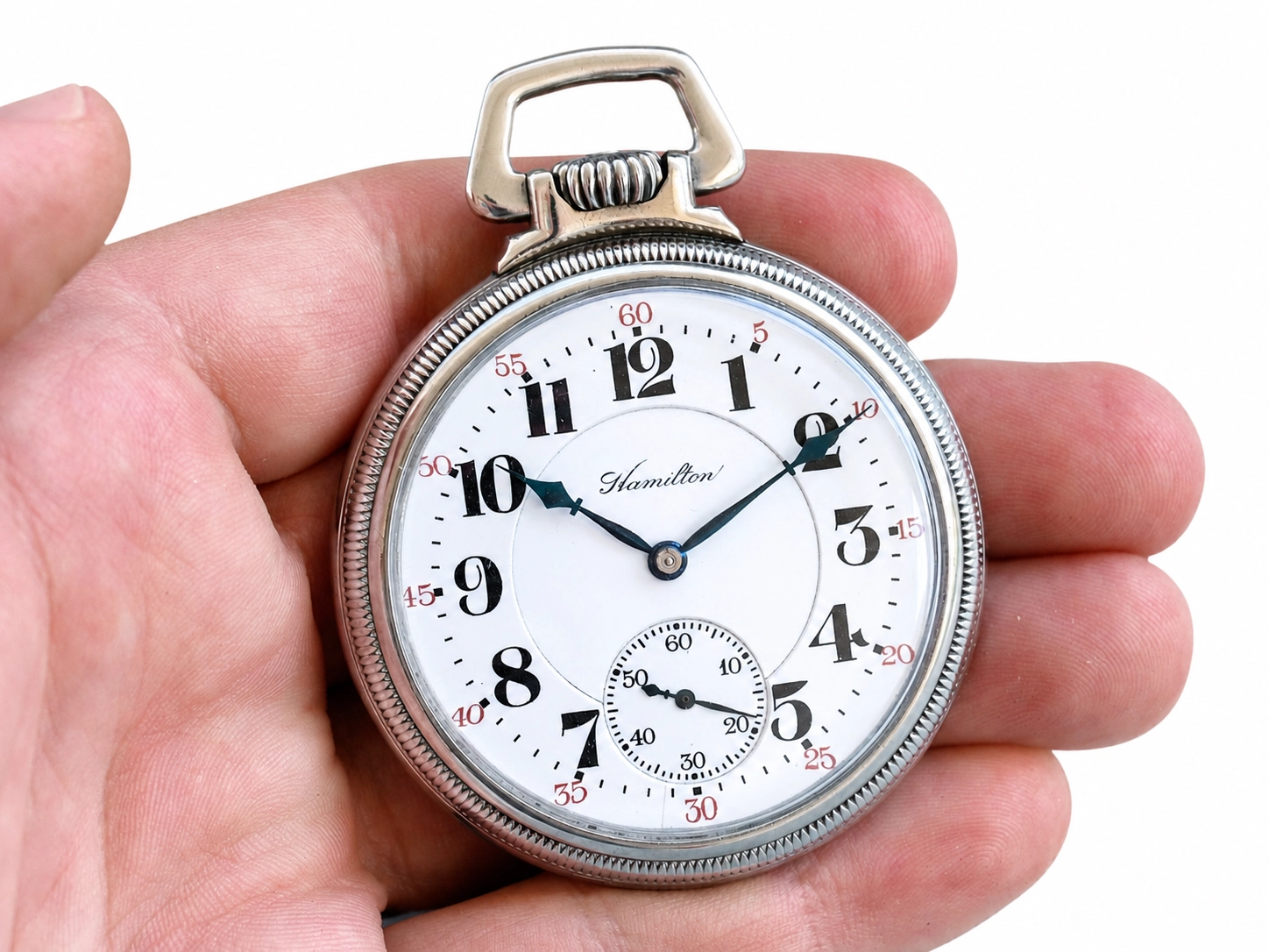 Open-face pocket watch with white dial, Arabic numerals, subsidiary seconds dial, and blued hands.