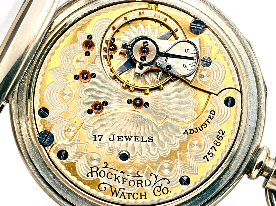 Rockford Grade 925 Hinged Display — open movement showing decorated balance wheel, gear train, jeweled bearings with blue screws