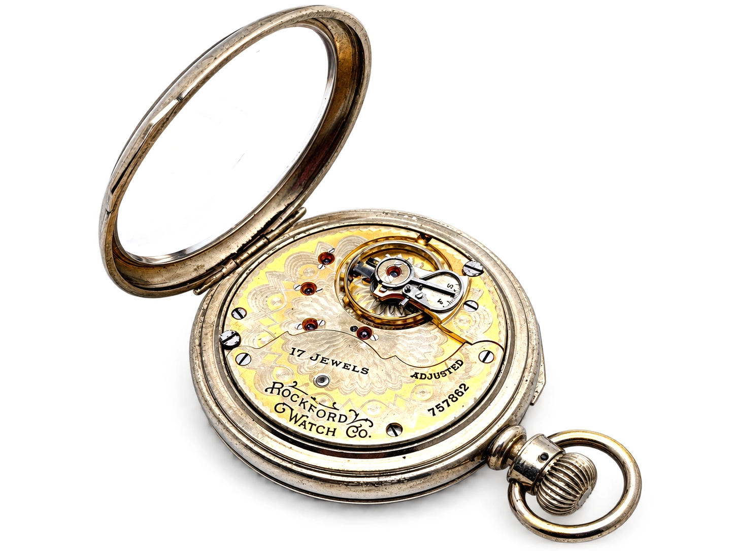 Rockford Grade 925 Hinged Display — open movement with yellow gilt decoration, red jewels visible in settings, and ornamental…