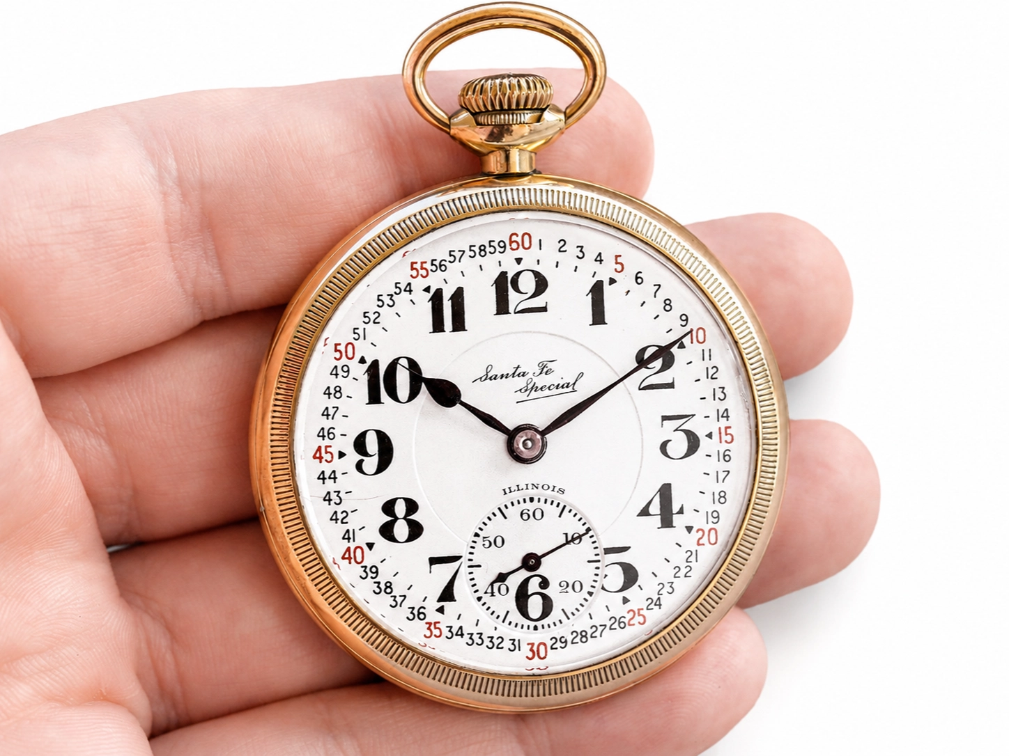 Gold open-face pocket watch with white dial, black Arabic numerals, subsidiary seconds dial, and blued hands.