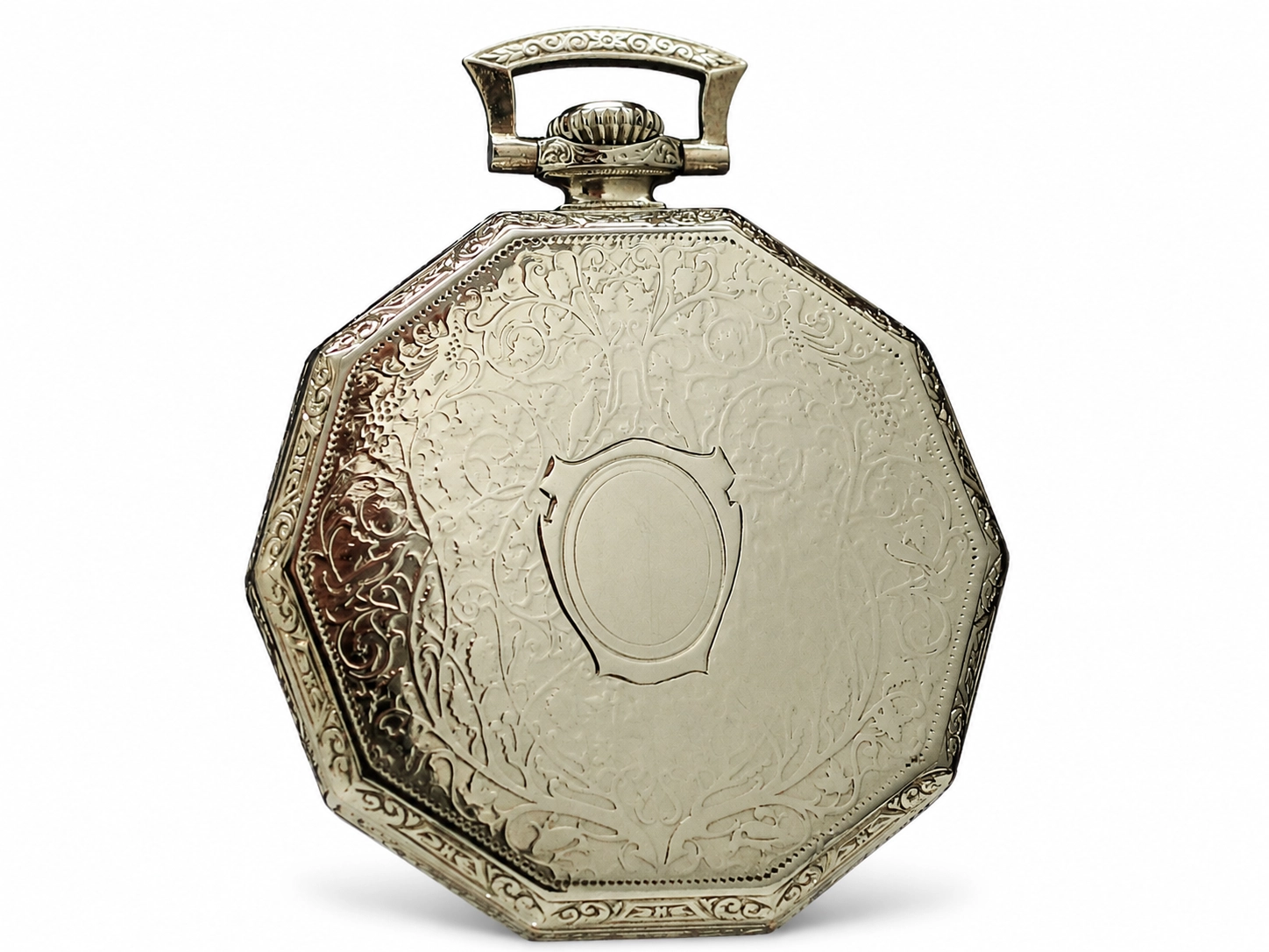 Octagonal silver pocket watch case with ornate scrollwork engraving and blank cartouche.