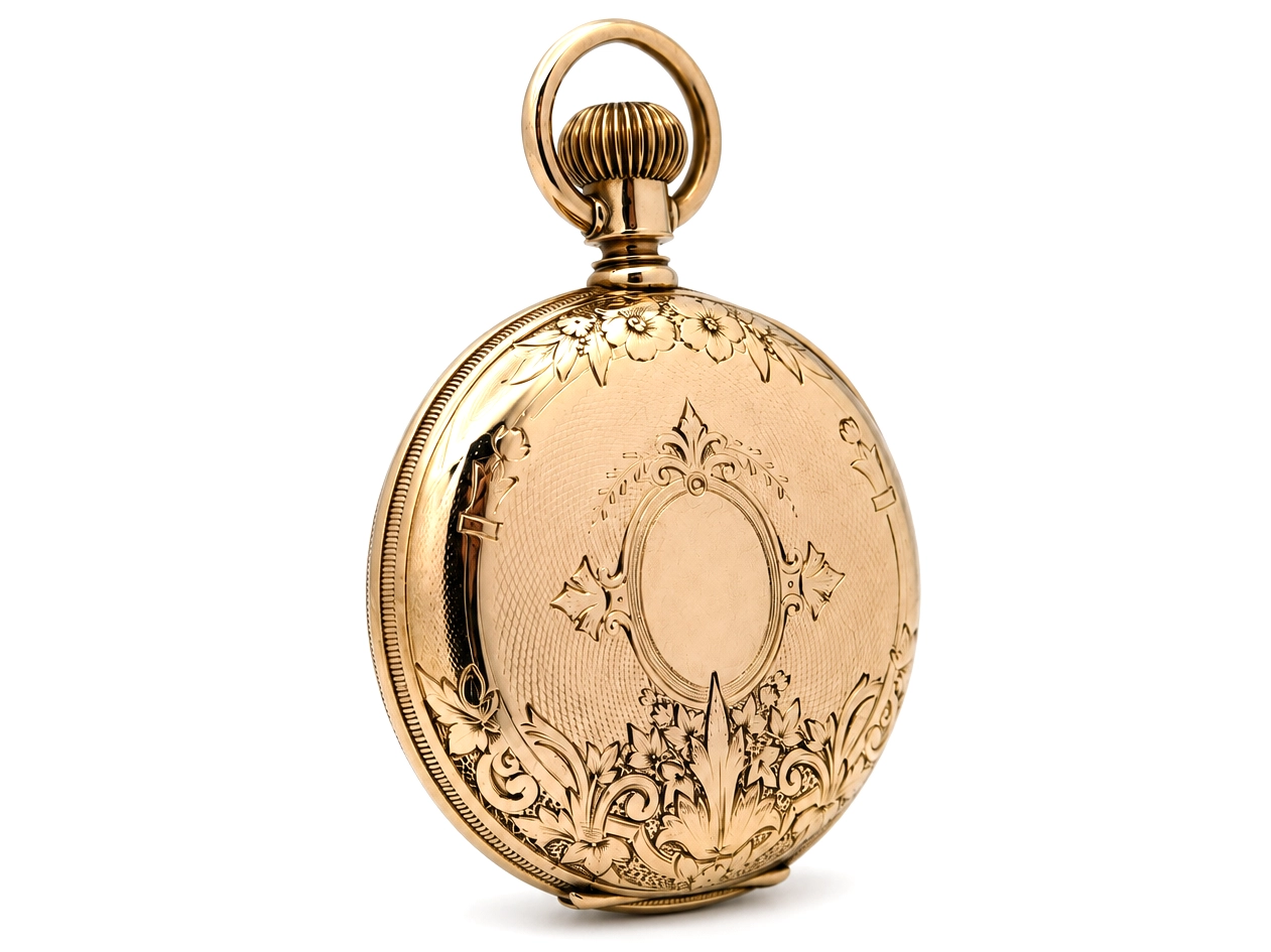 Engraved gold pocket watch case back with ornamental floral and geometric designs.