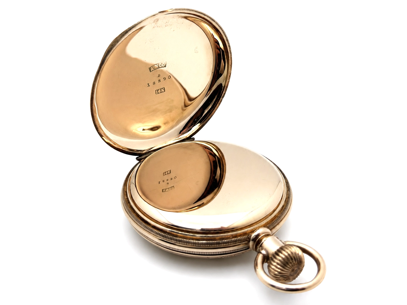 Opened pocket watch case revealing gold interior surfaces with hallmarks and serial number engravings visible.